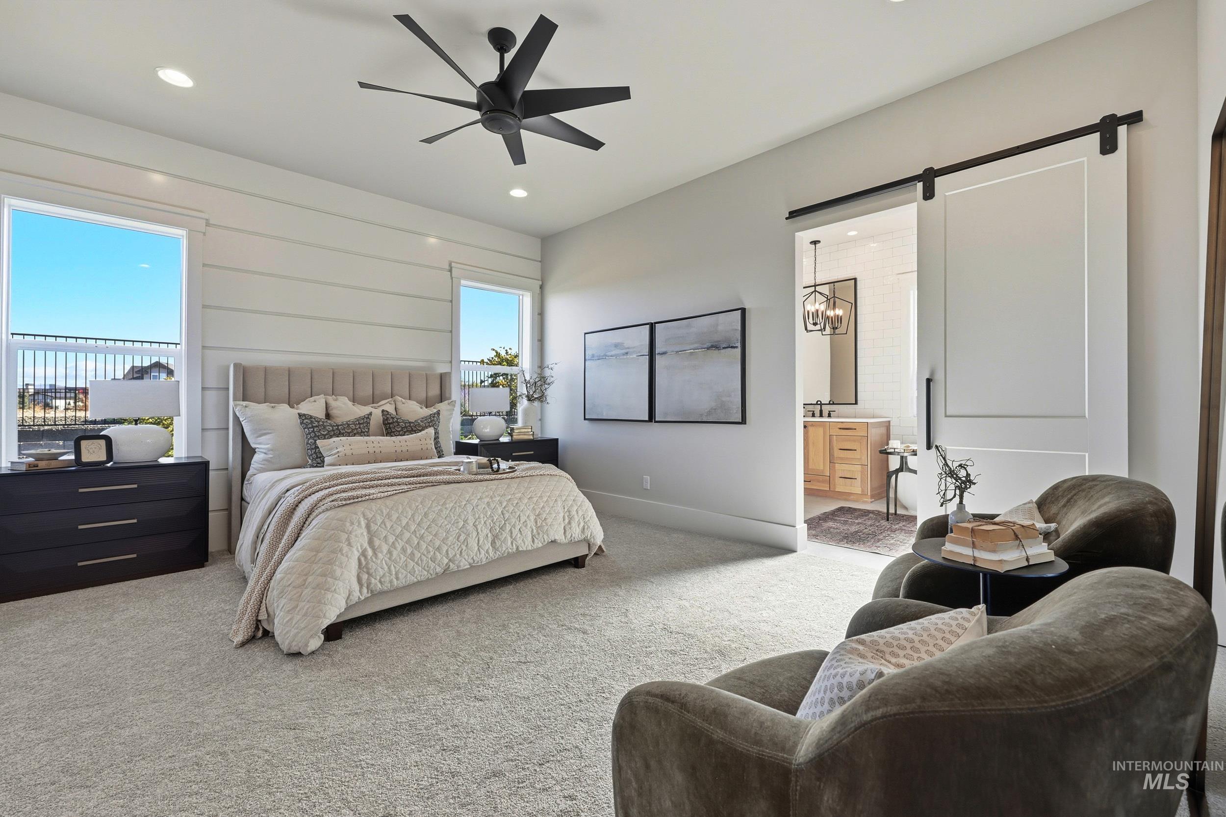 Carpeted bedroom with a barn door, recessed lighting, connected bathroom, and ceiling fan