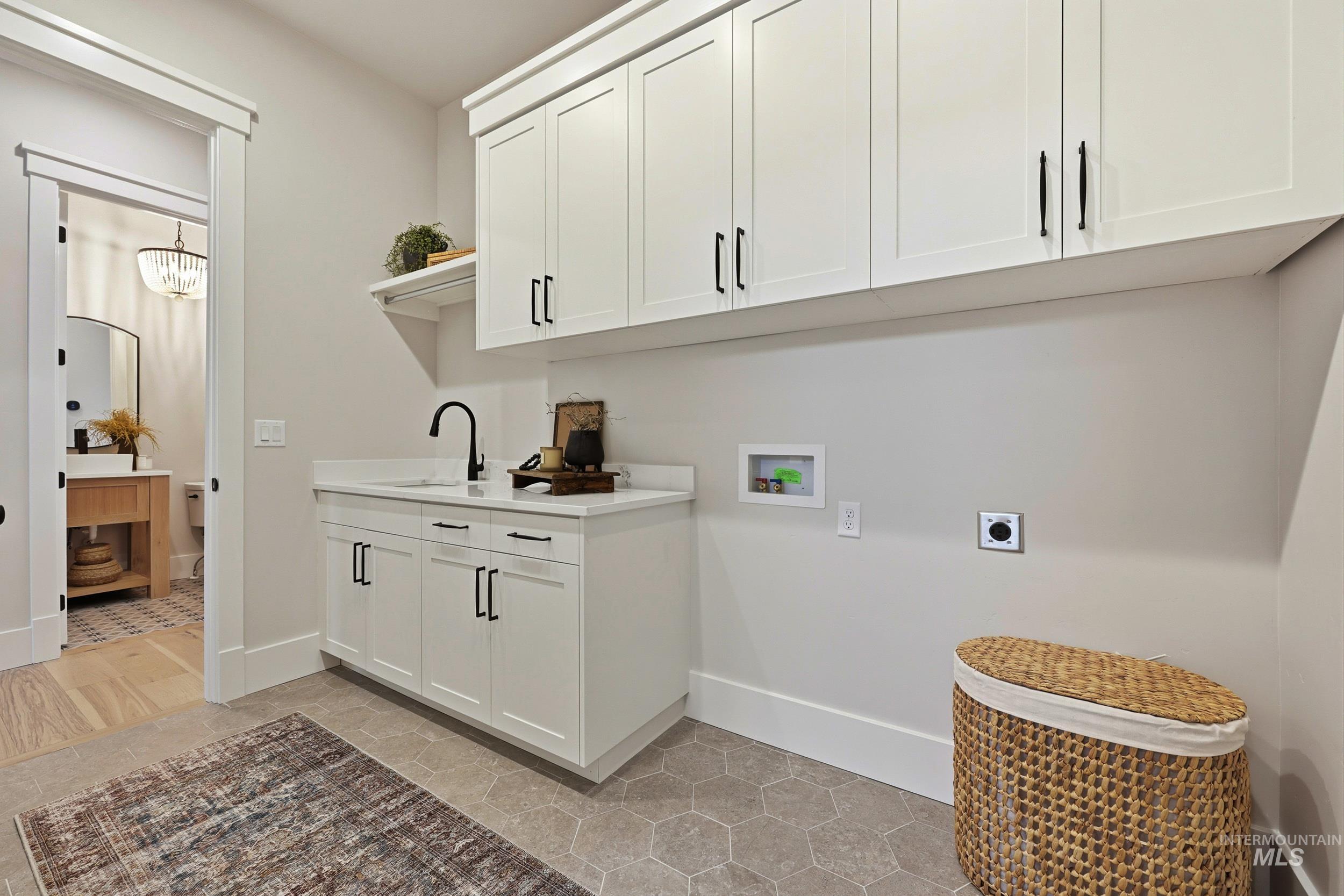 Laundry room featuring washer hookup, electric dryer hookup, light tile patterned flooring, and cabinet space