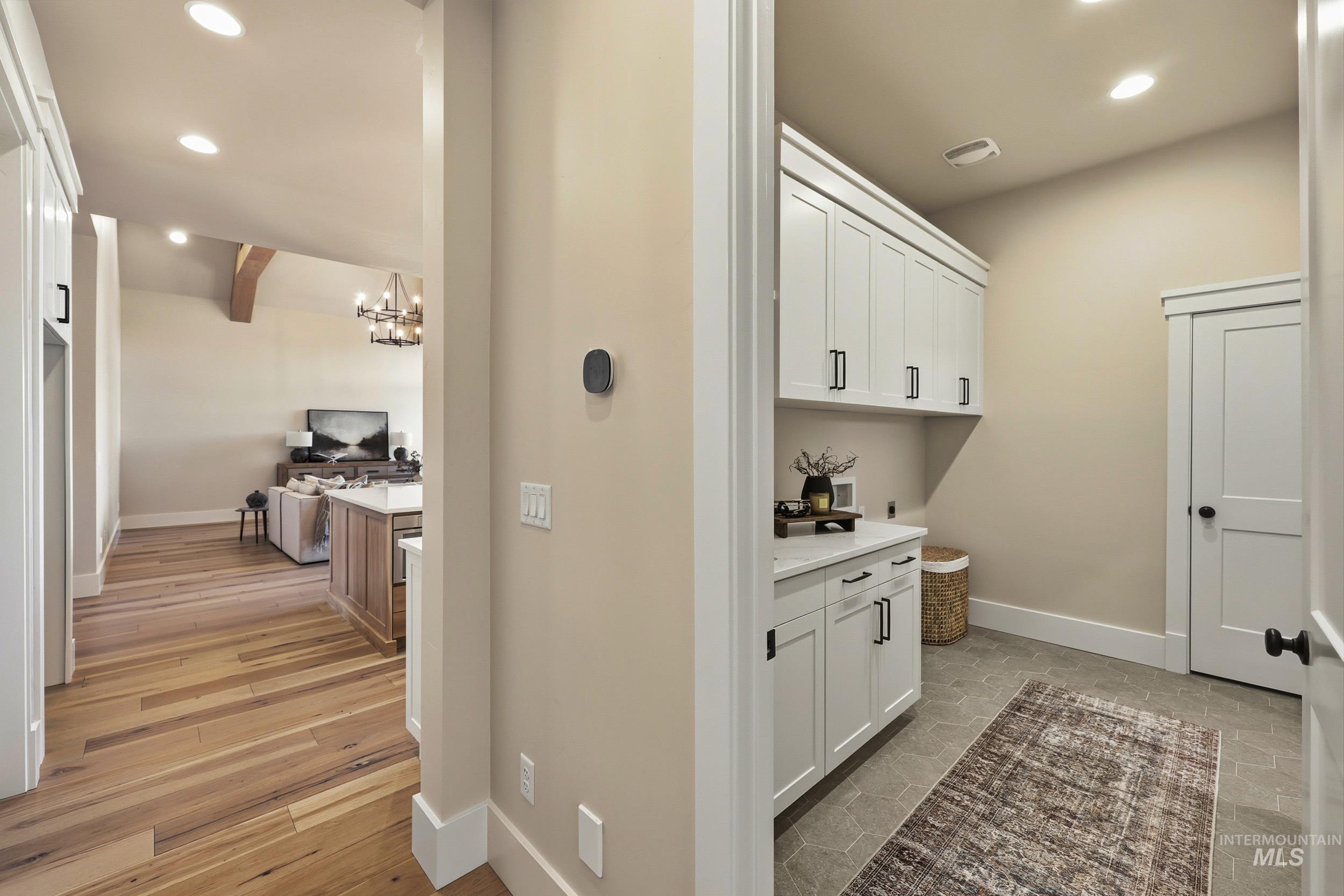 Laundry room with recessed lighting and a chandelier
