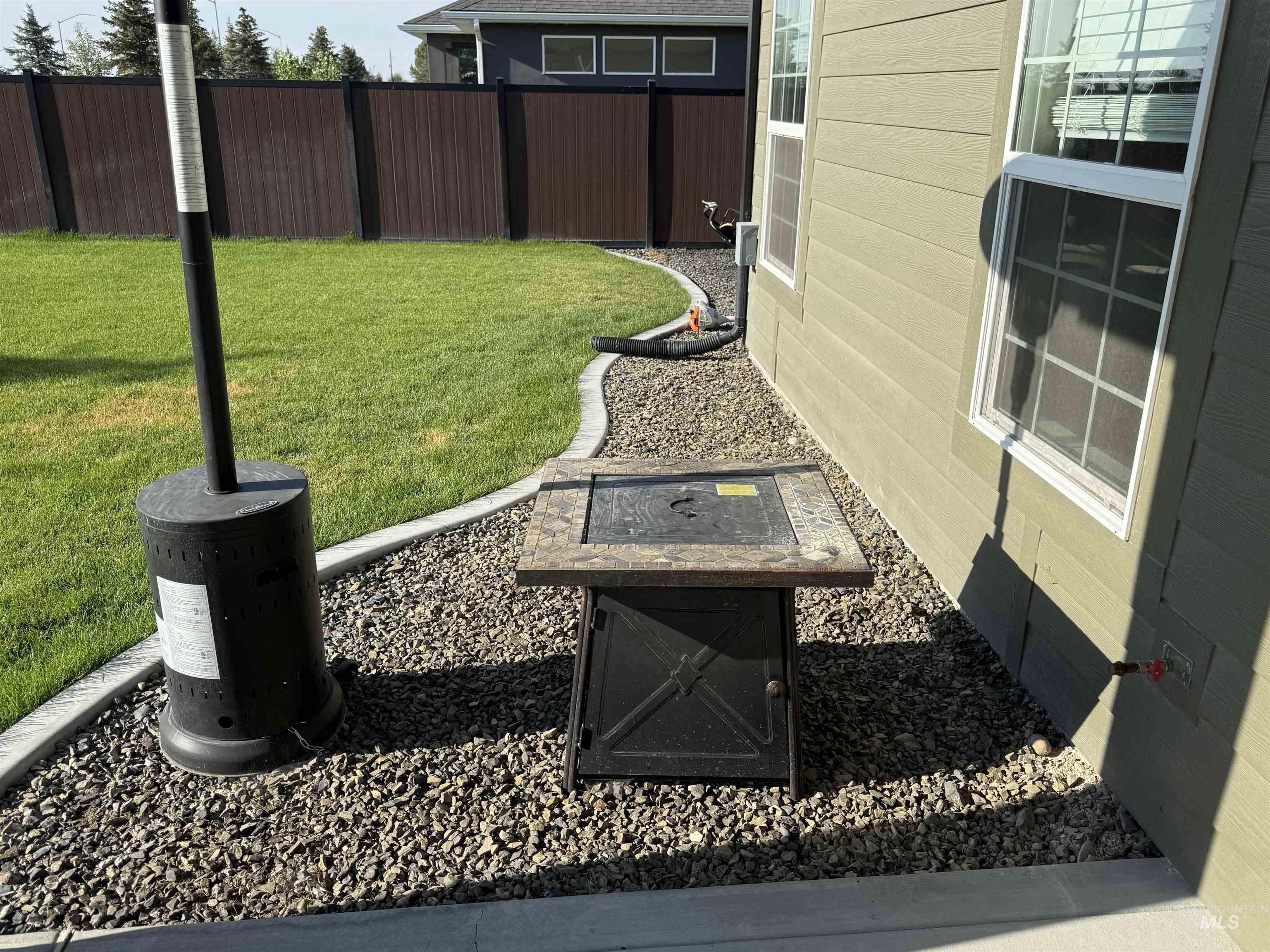 Fenced yard with an outdoor fire pit and a patio