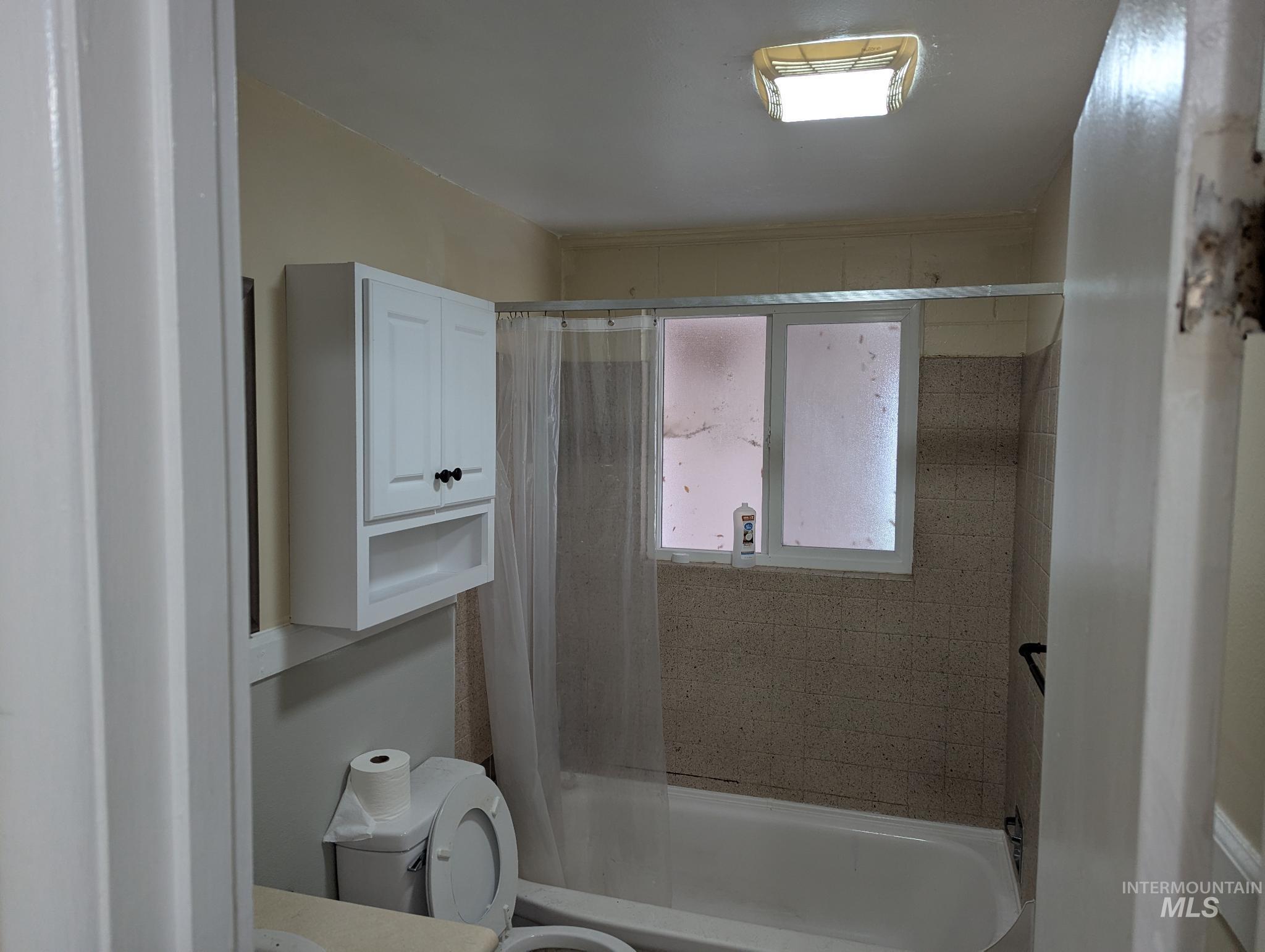 Bathroom featuring shower / tub combo with curtain and vanity