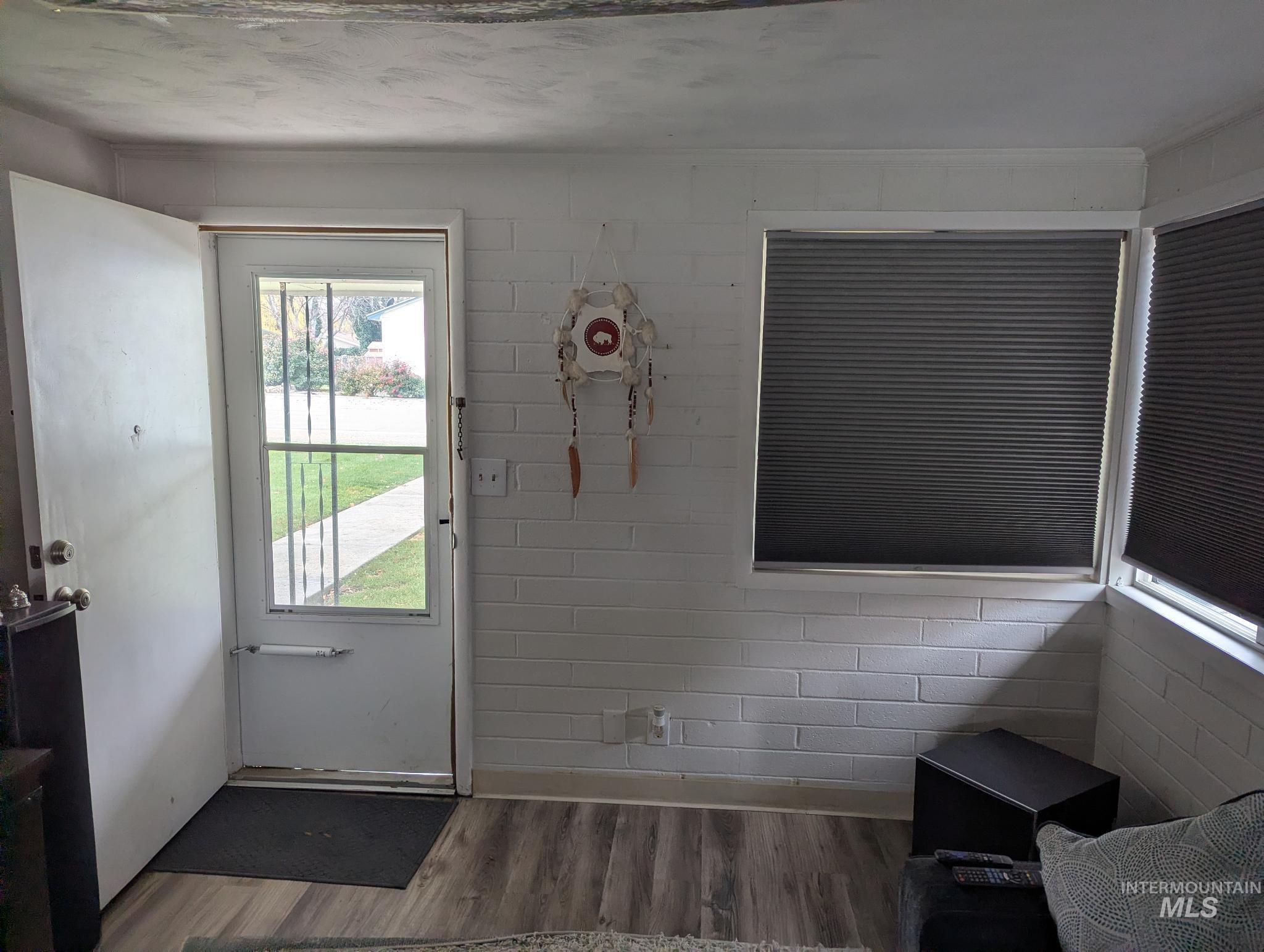 Doorway featuring wood finished floors and baseboards