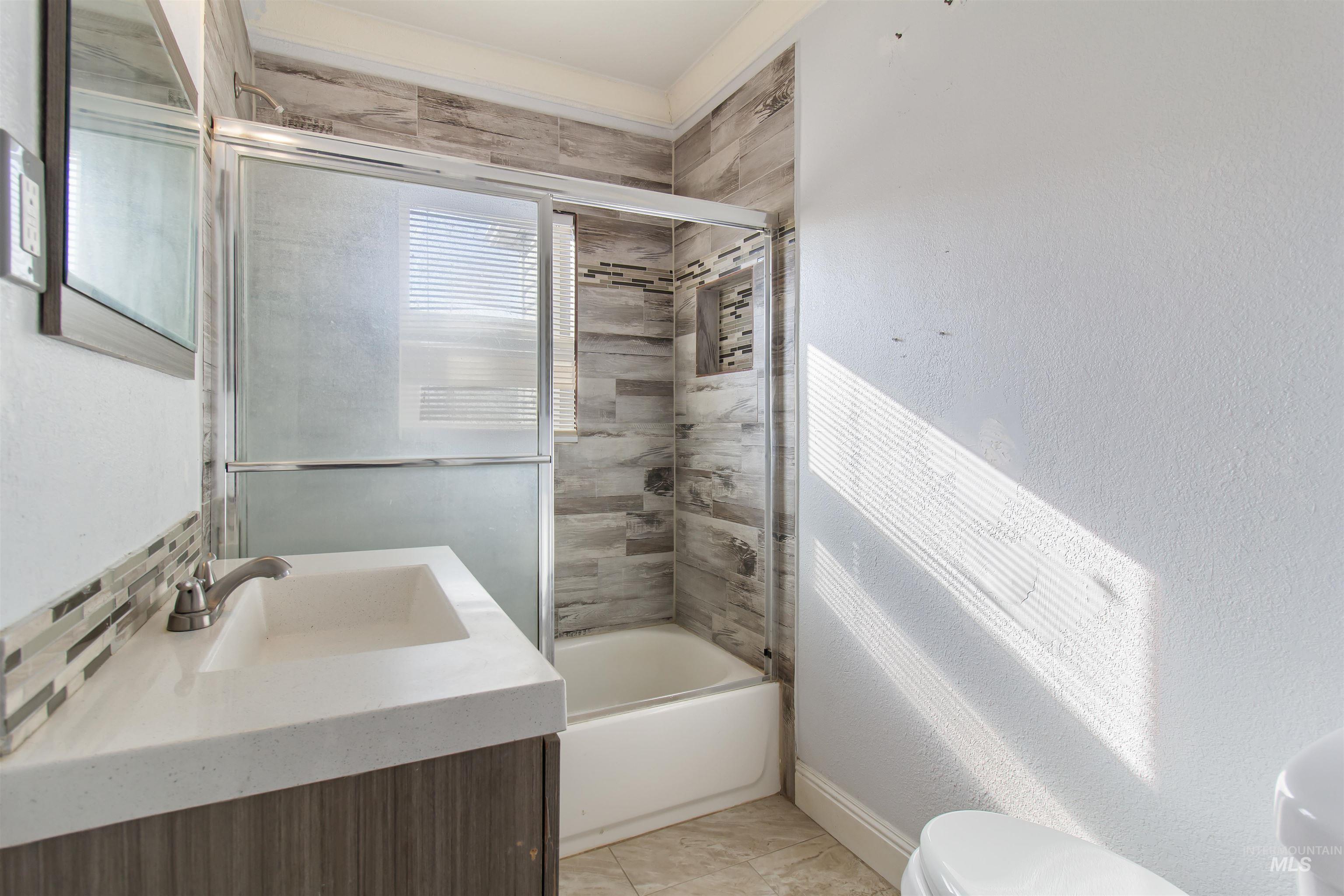 Full bath with vanity and enclosed tub / shower combo