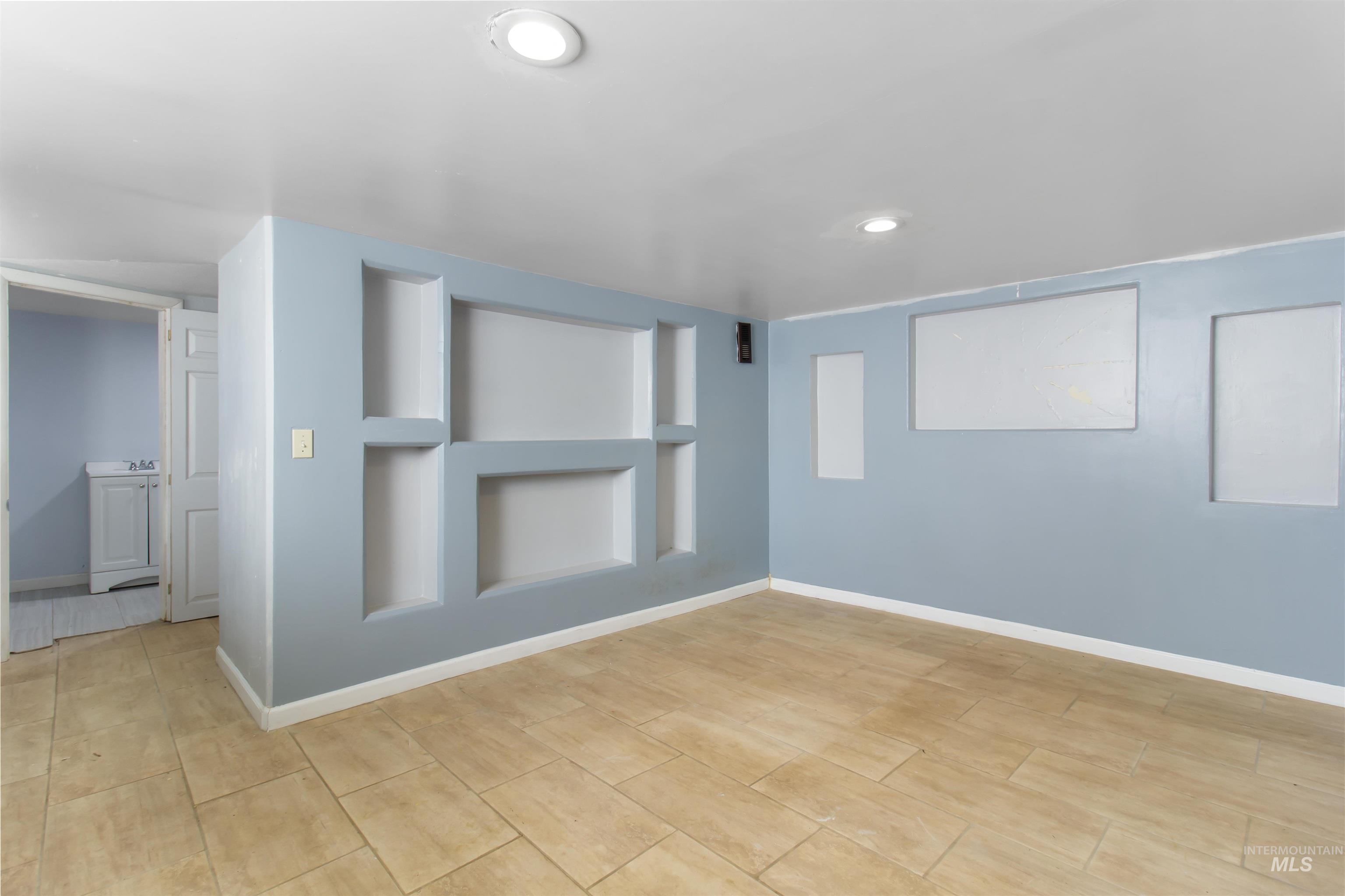 Unfurnished room with built in features and recessed lighting