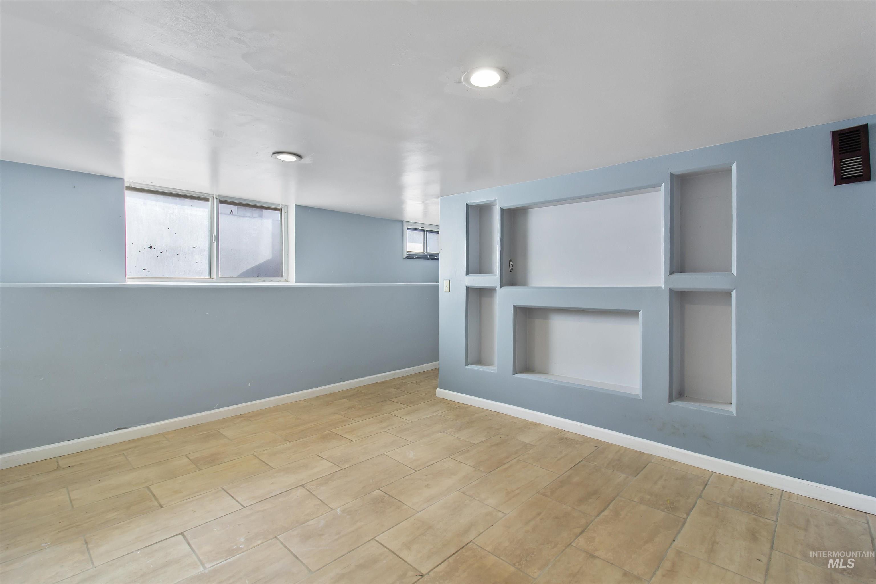 Spare room featuring built in features and plenty of natural light