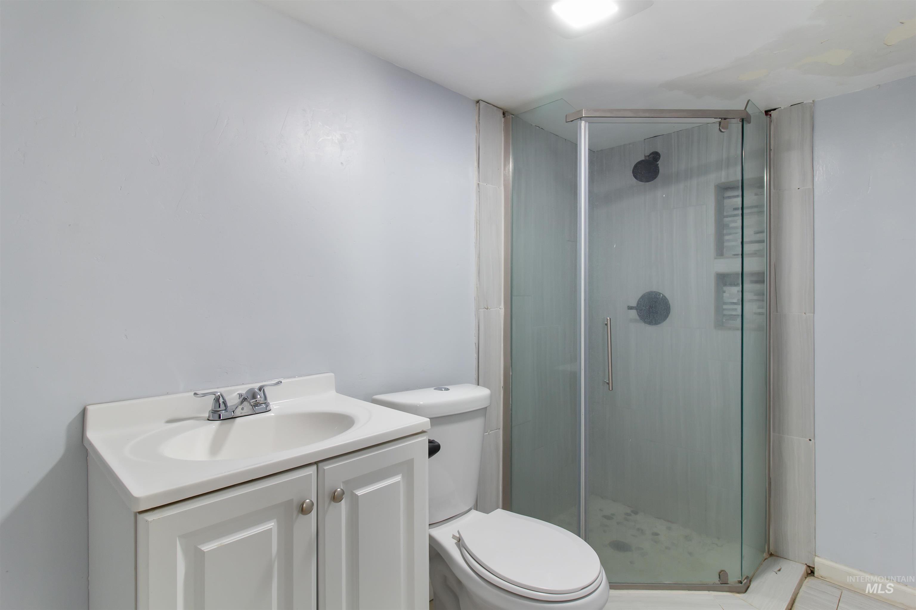 Bathroom featuring vanity and a shower stall