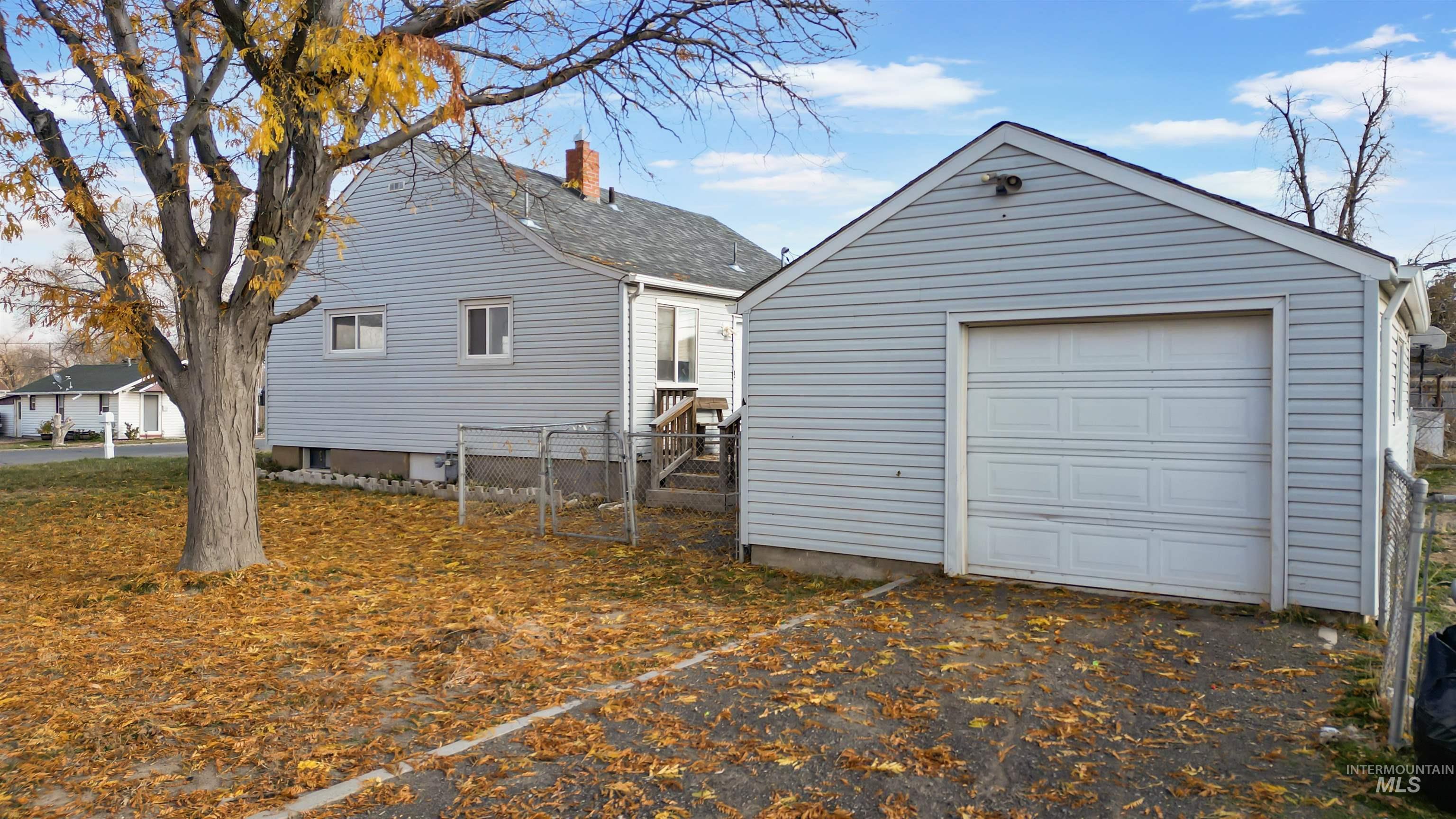 View of home's exterior with an outbuilding, a chimney, and a garage