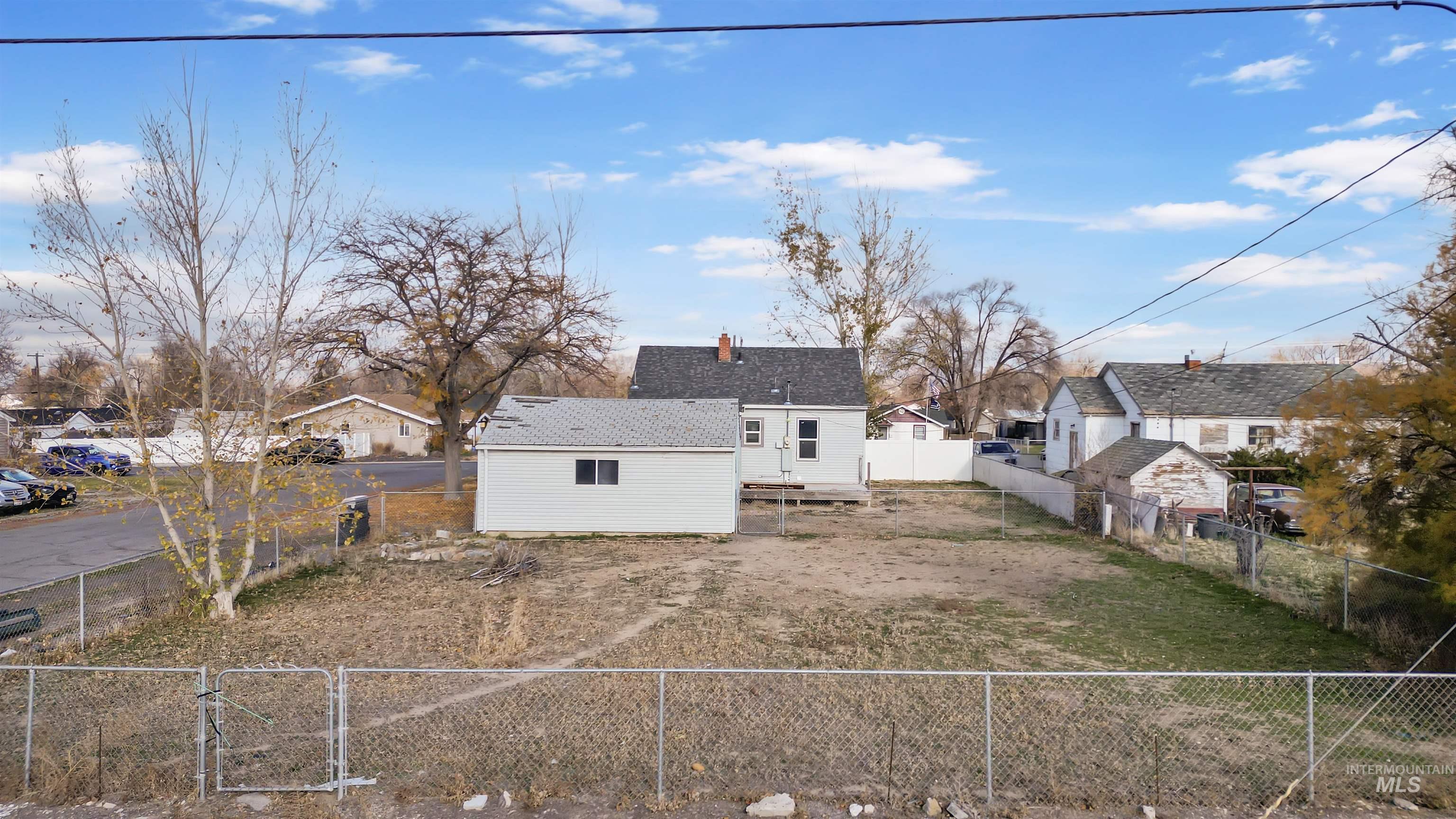 Rear view of property with a fenced backyard, a residential view, and a chimney