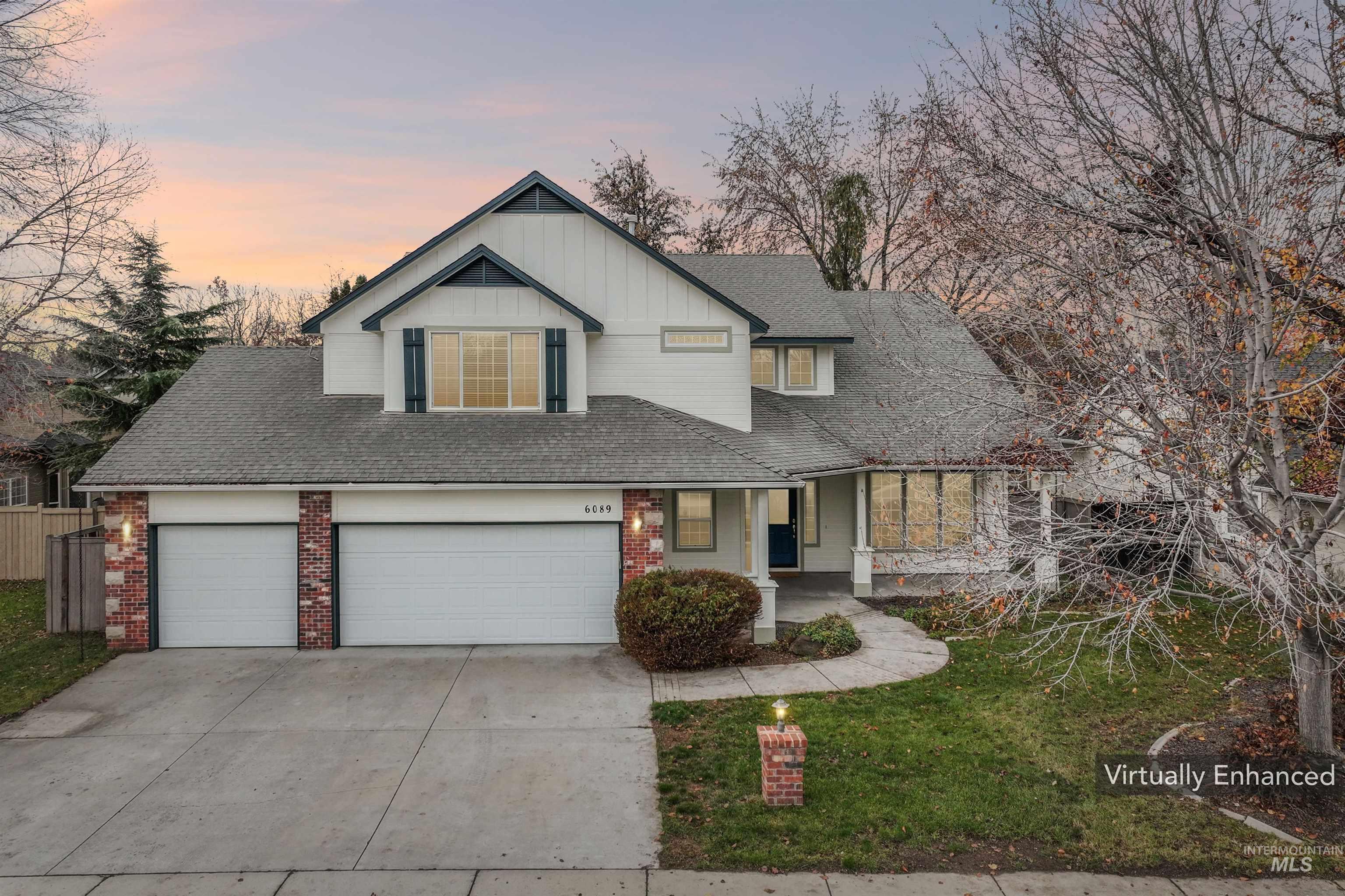 View of front facade with concrete driveway, board and batten siding, covered porch, a garage, and brick siding