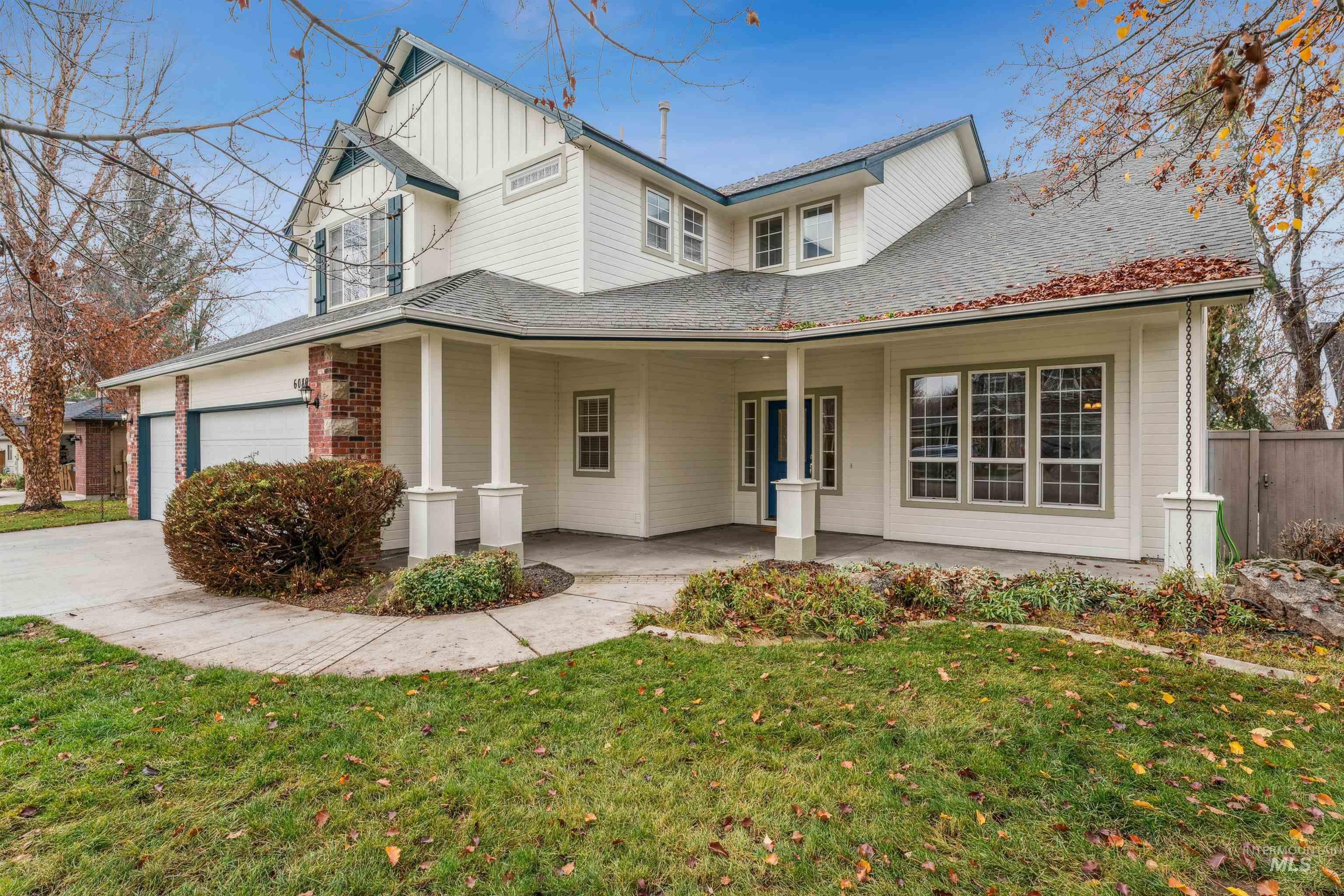 View of front of home featuring board and batten siding, a porch, driveway, and an attached garage