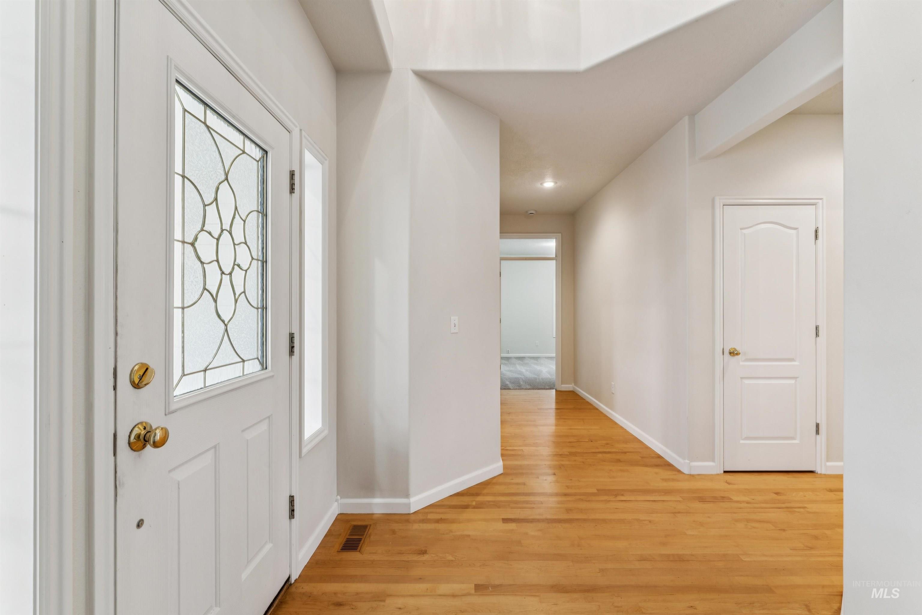 Entryway with baseboards and light wood-style flooring