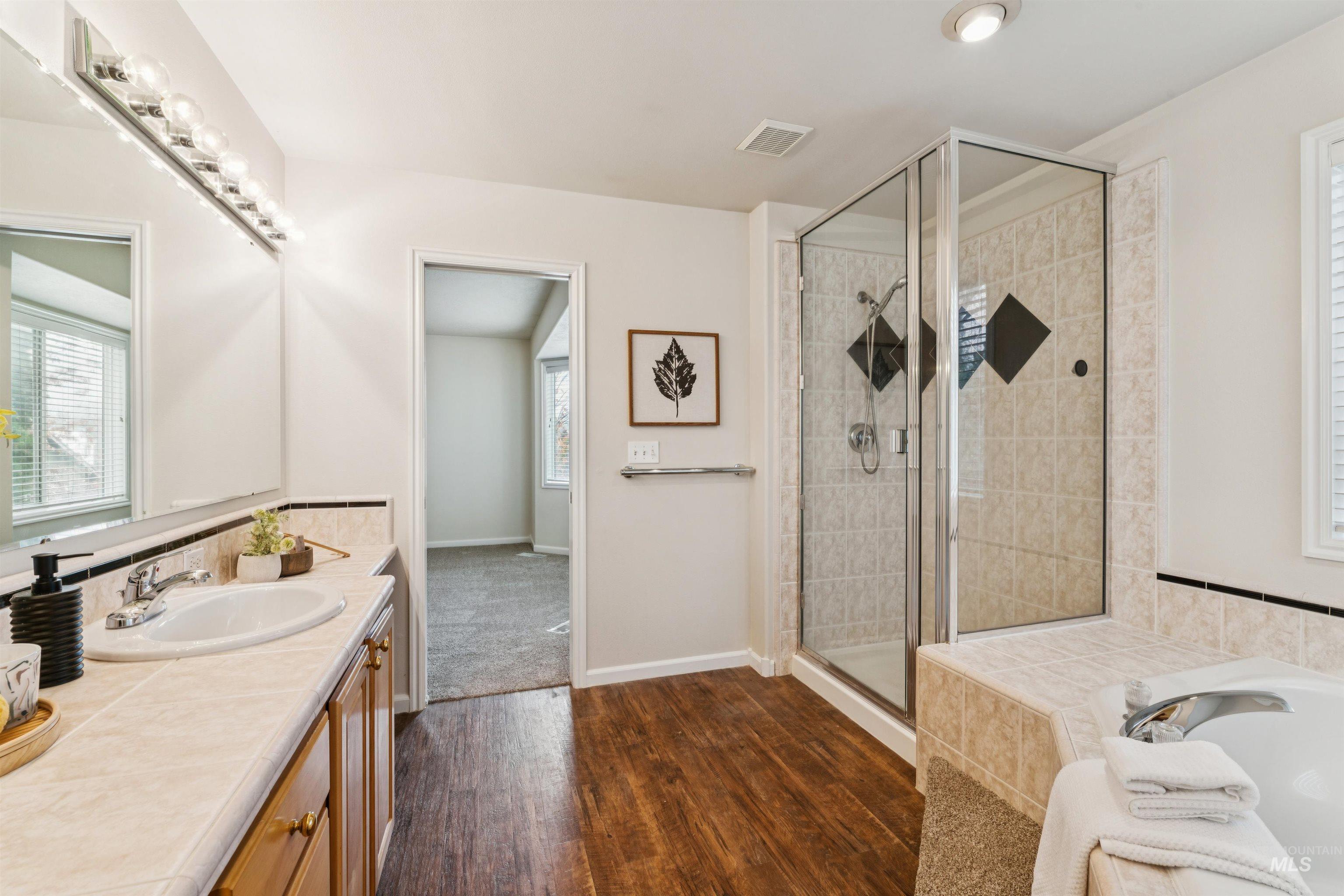 Bathroom with plenty of natural light, vanity, and a bath