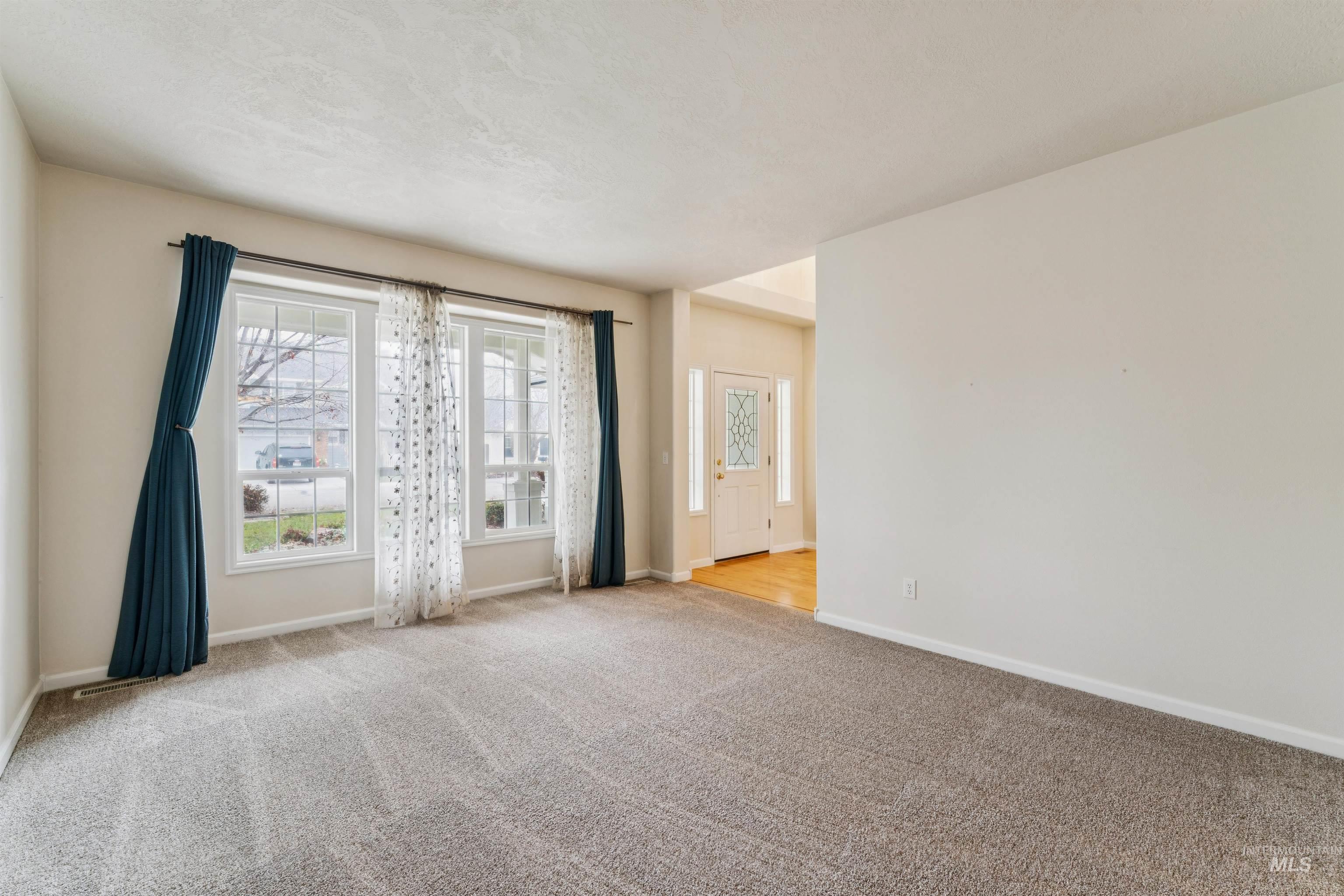 Spare room with baseboards and light carpet