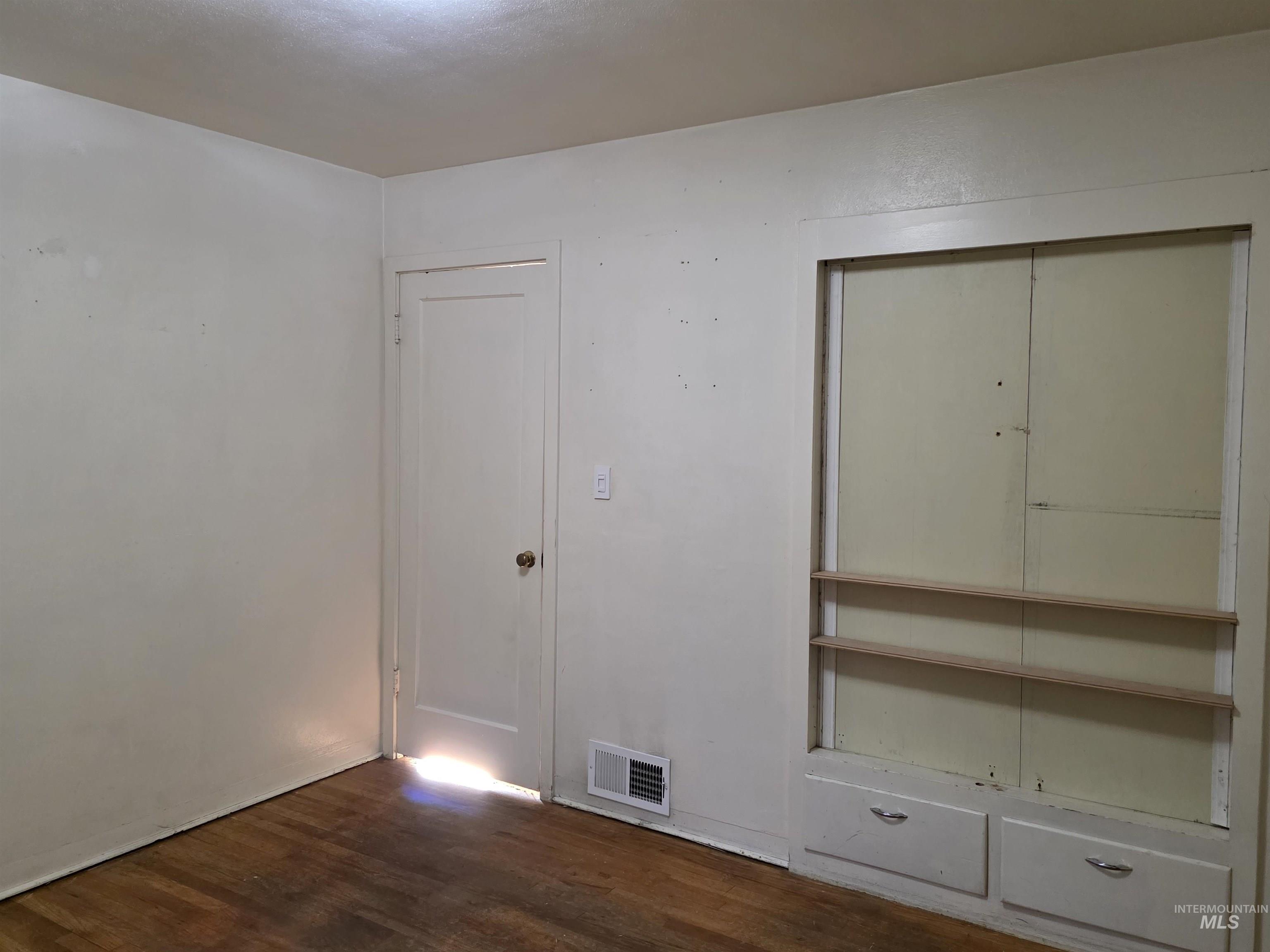 Unfurnished bedroom with dark wood-style floors