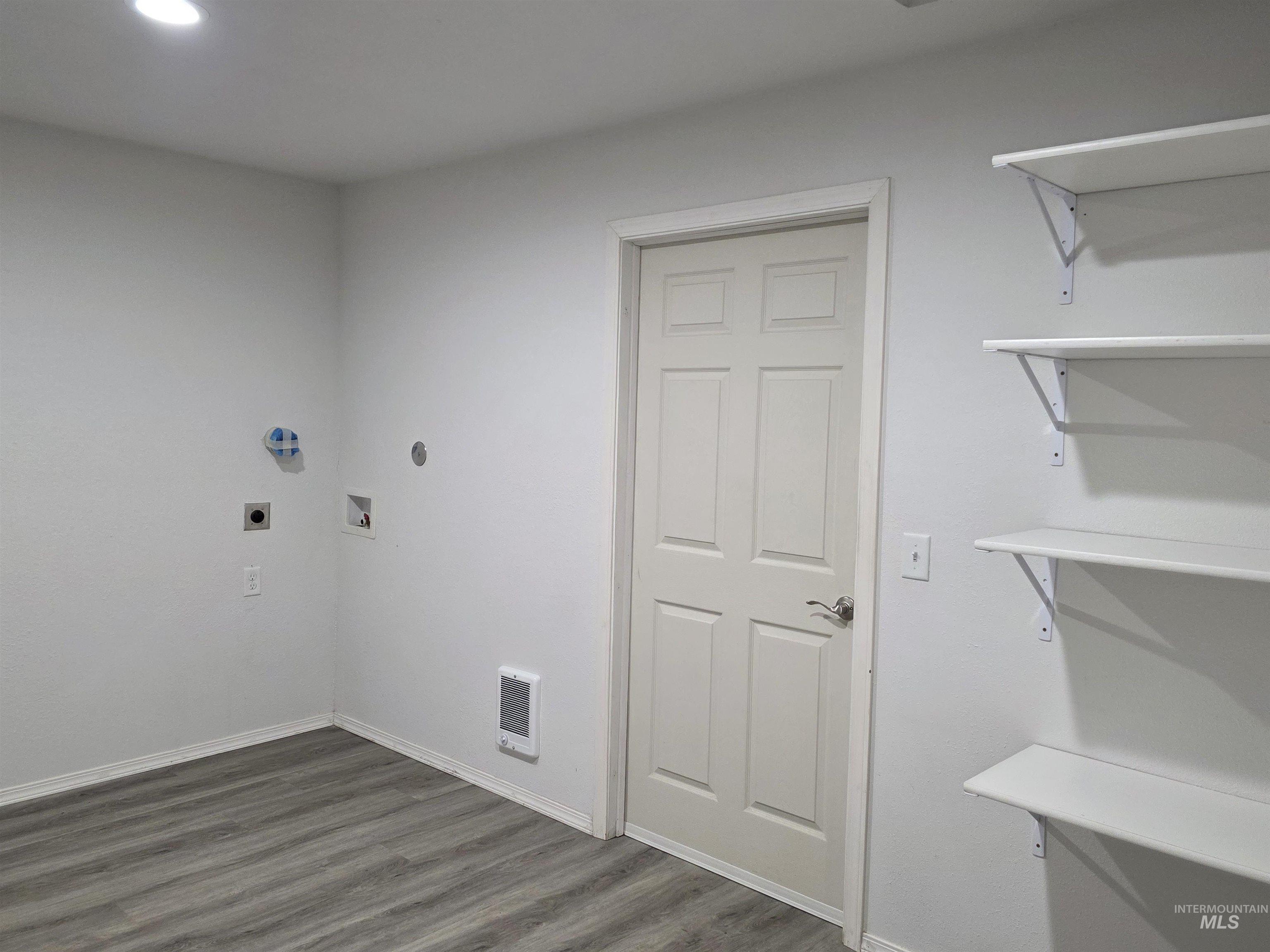 Laundry area with dark wood-style floors, hookup for a washing machine, and electric dryer hookup