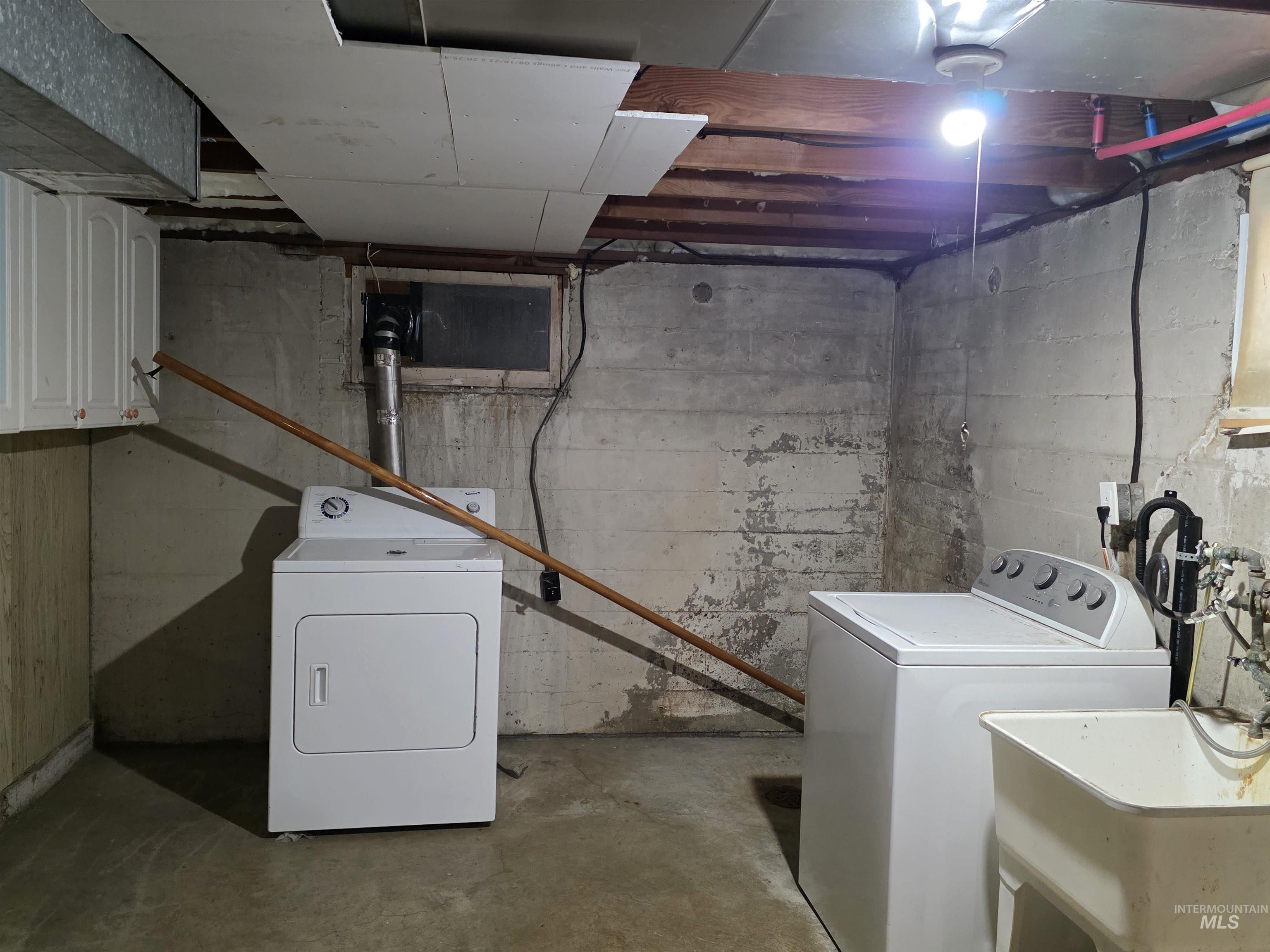 Laundry room with unfinished concrete flooring and washing machine and clothes dryer