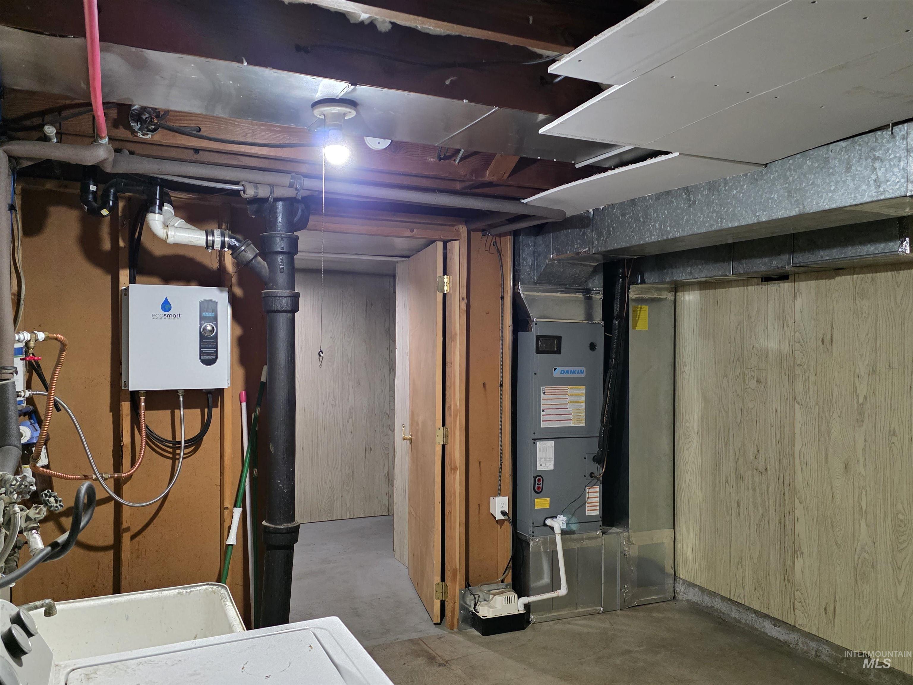 Unfinished below grade area with wooden walls, heating unit, and washer / dryer