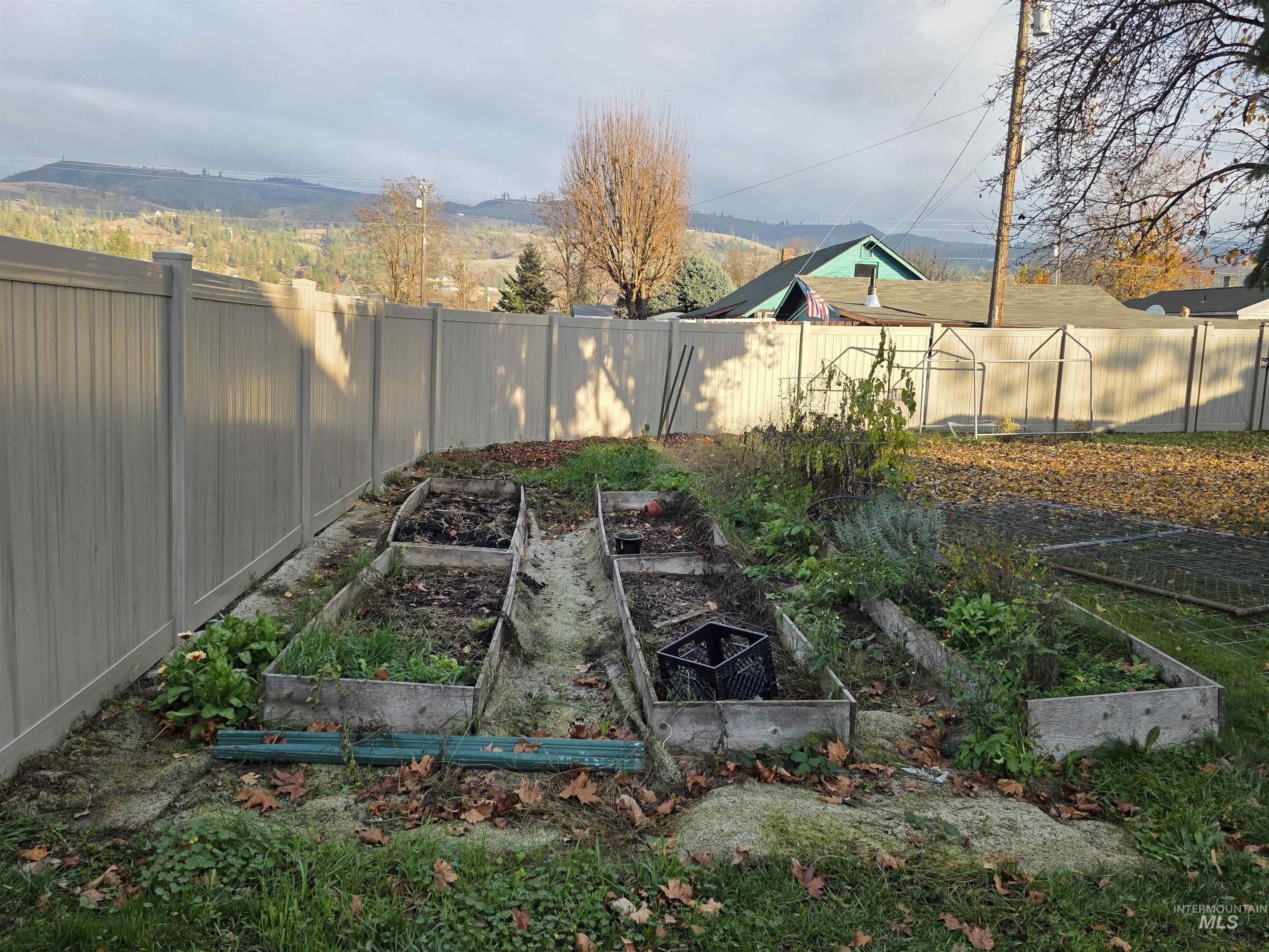 Fenced backyard featuring a vegetable garden