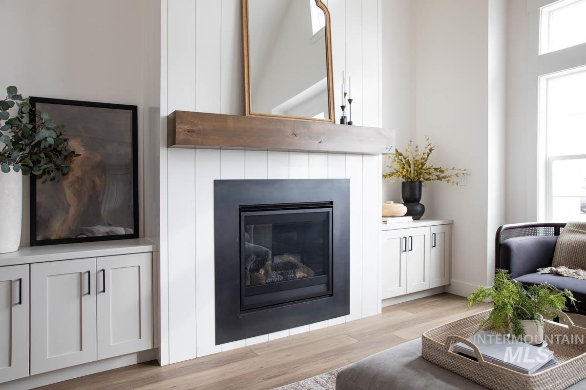 Living area featuring light wood-style flooring and a glass covered fireplace