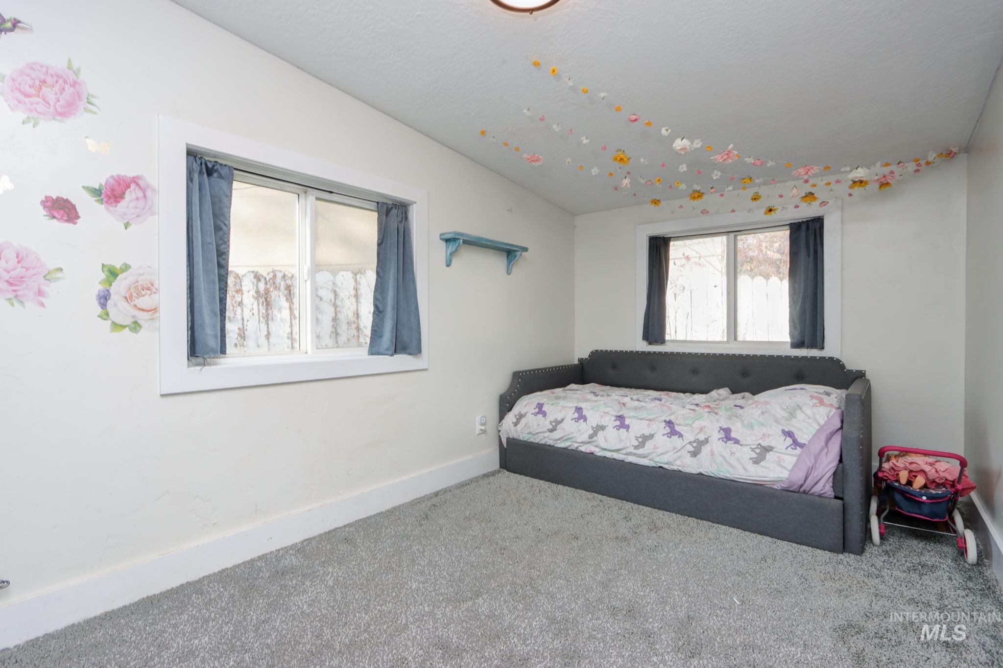Bedroom featuring carpet and baseboards