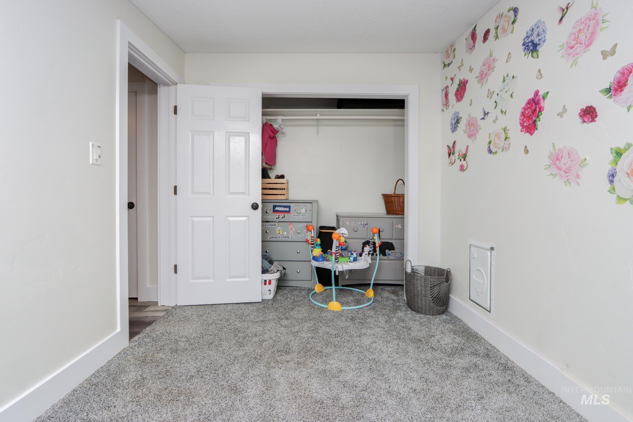Carpeted bedroom with baseboards and a closet