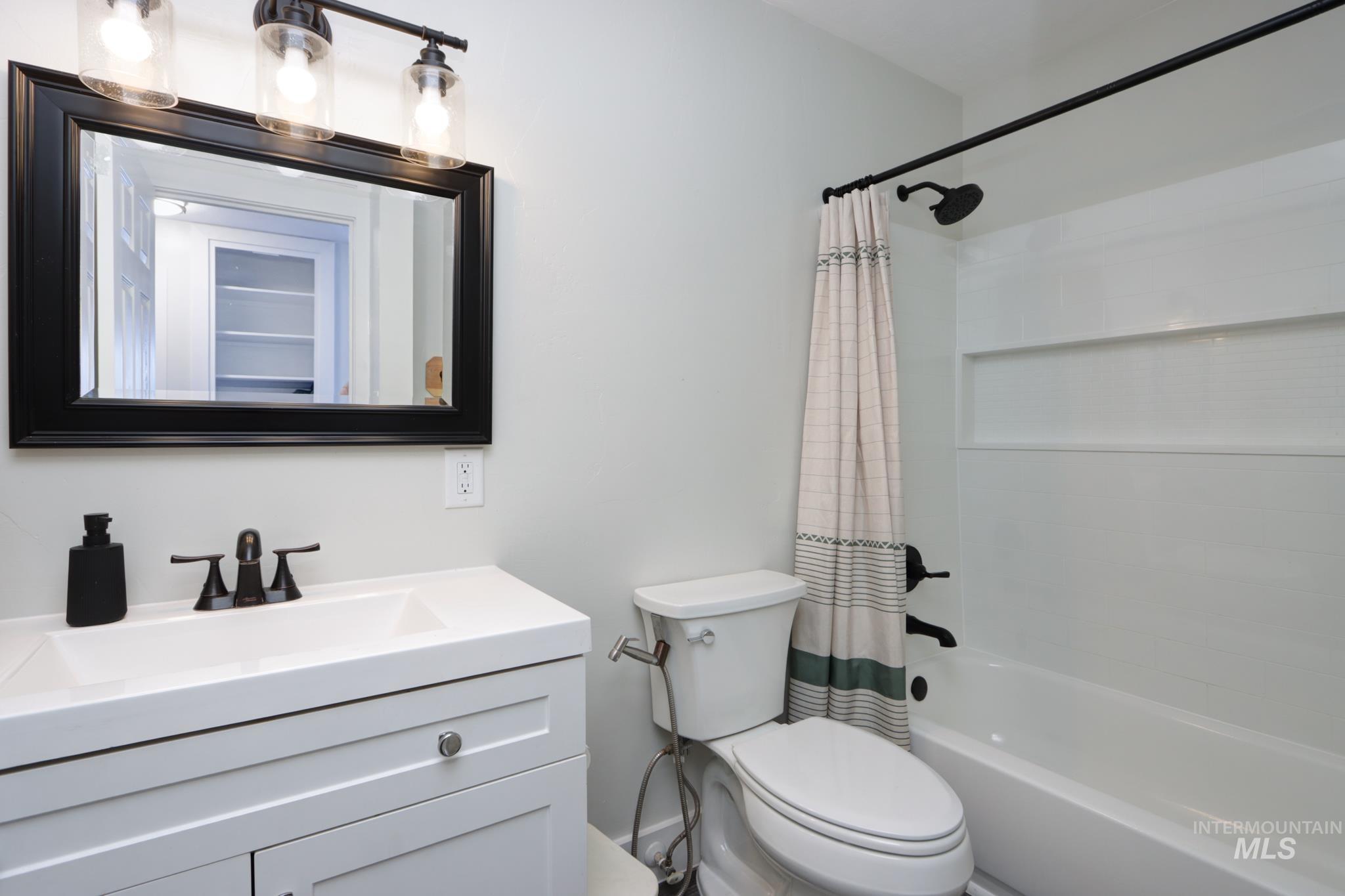 Full bath featuring shower / bathtub combination with curtain and vanity