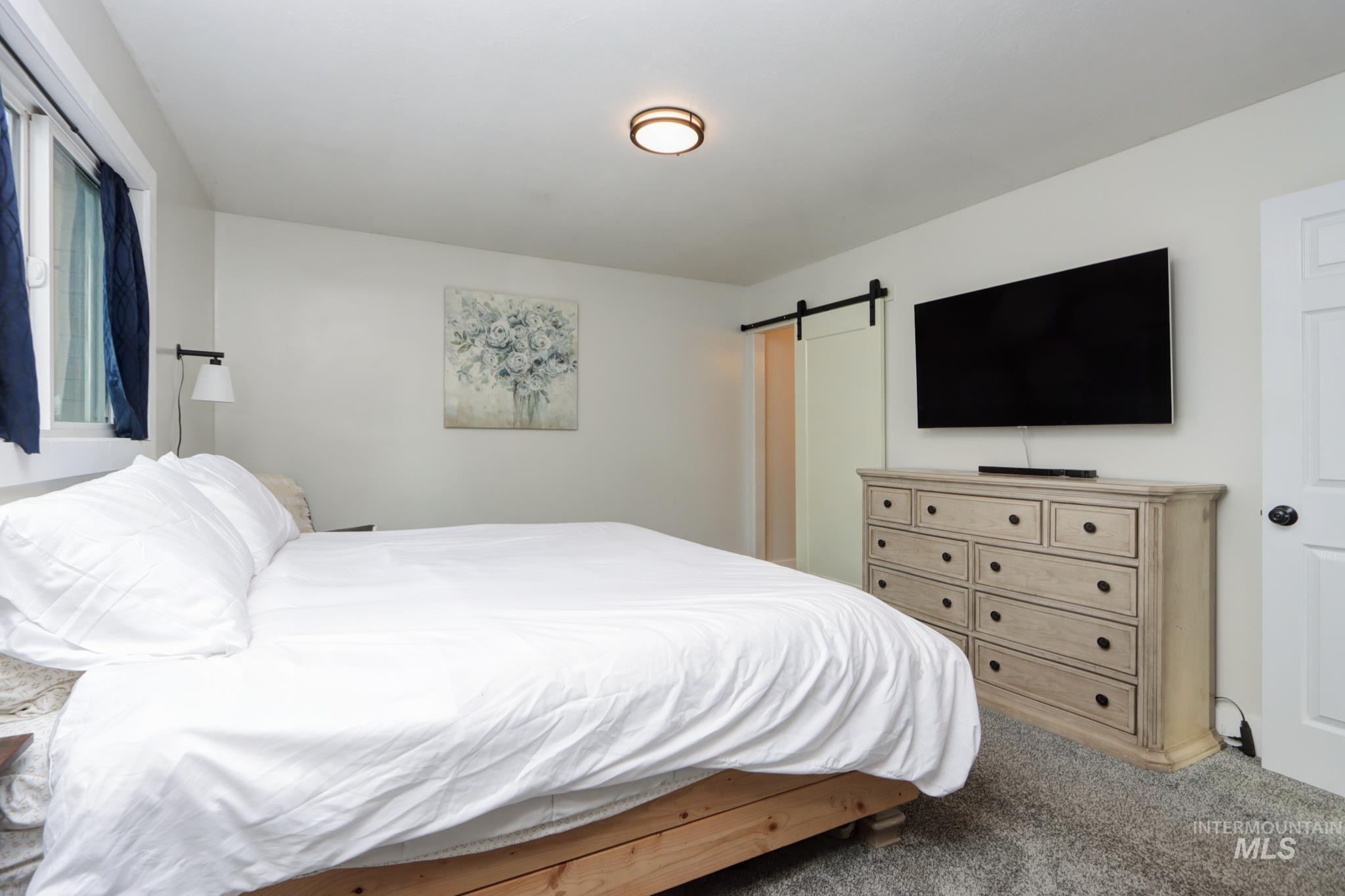 Carpeted bedroom with a barn door