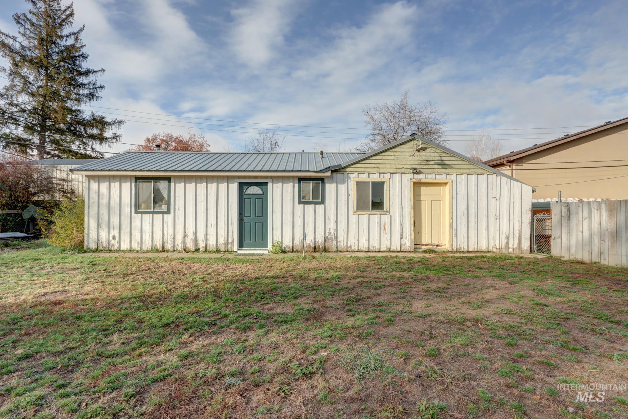 View of front of property with board and batten siding and a metal roof