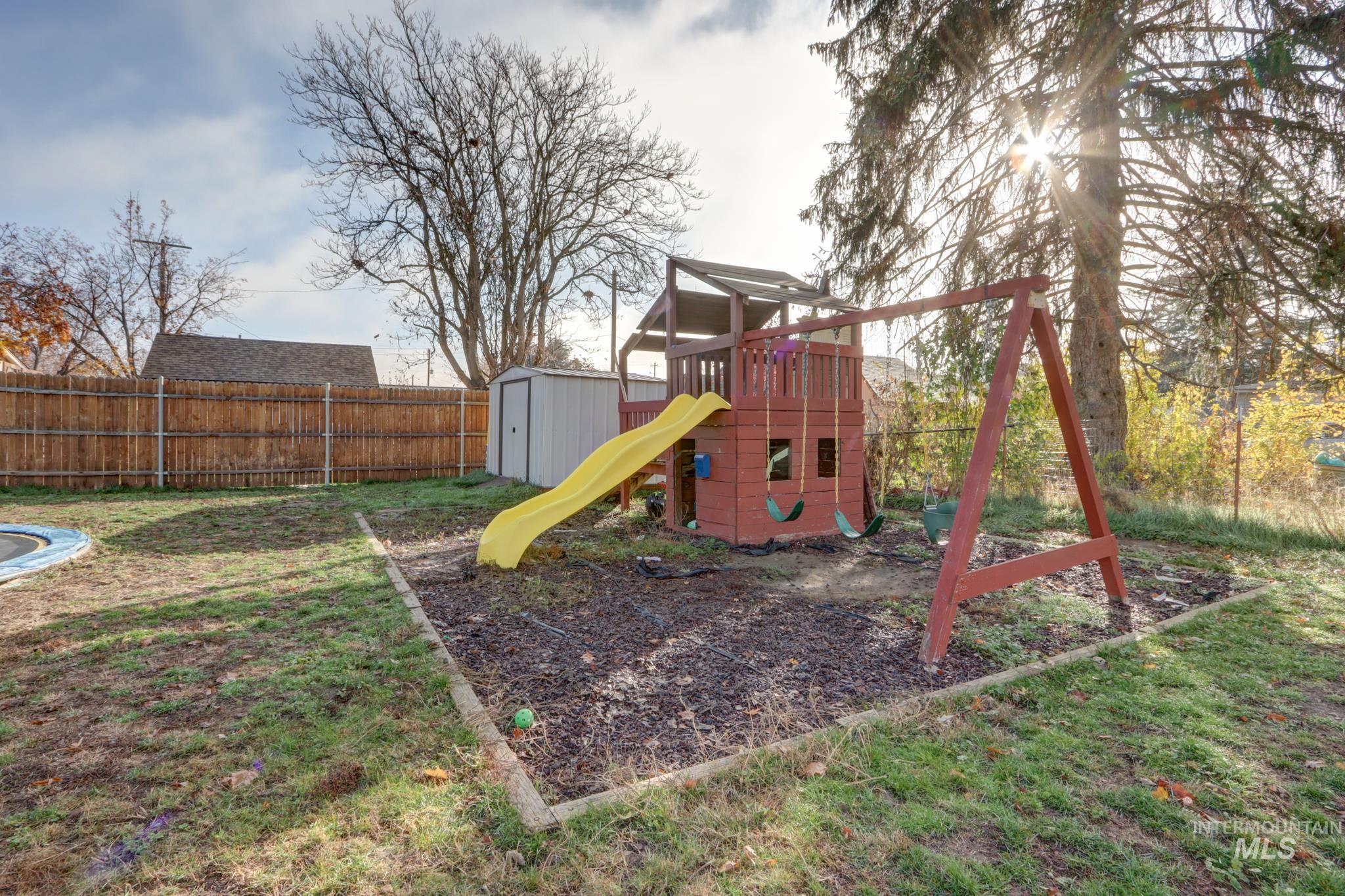 View of jungle gym featuring a shed and a fenced backyard