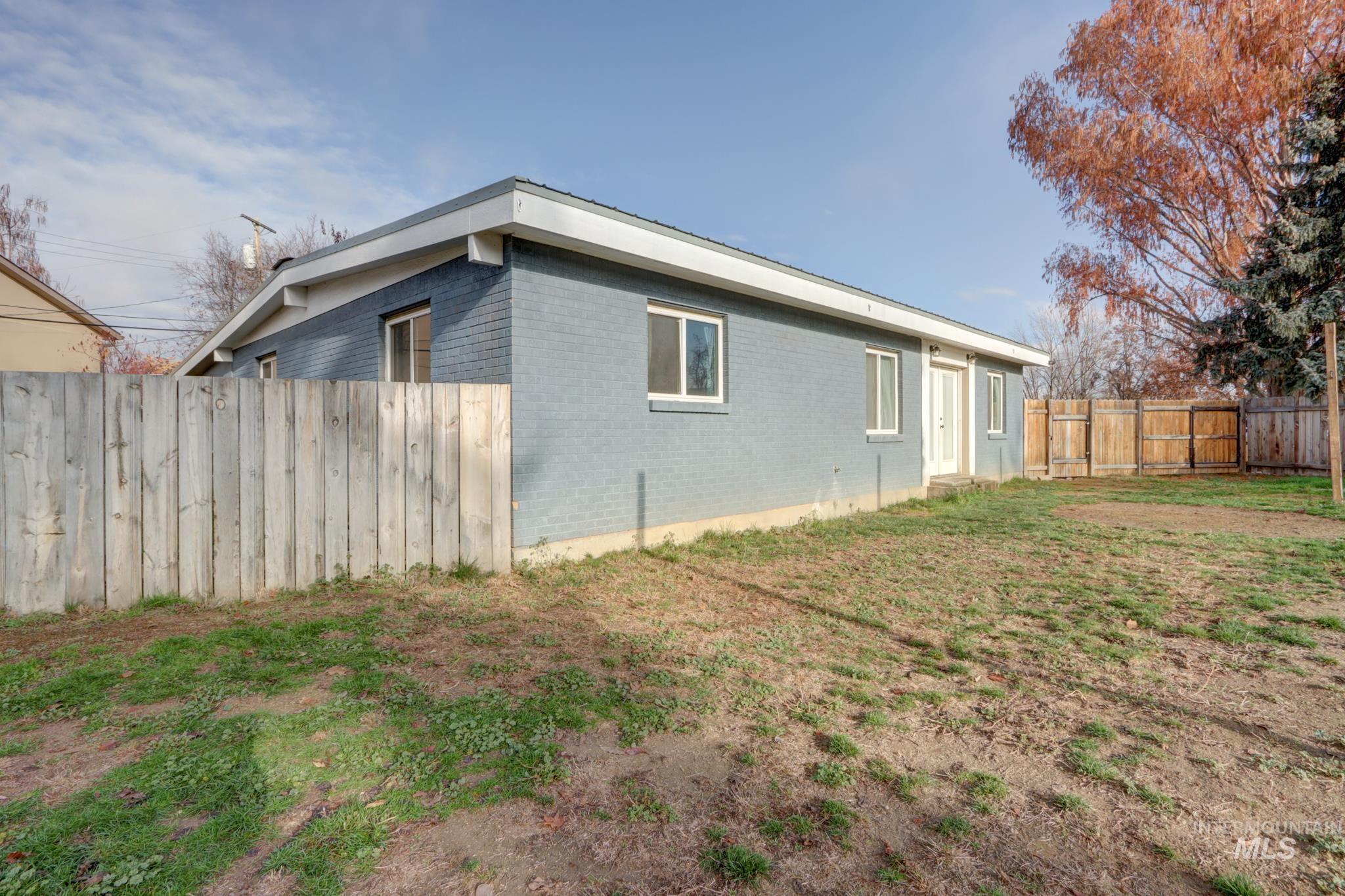 View of property exterior with a fenced backyard and brick siding