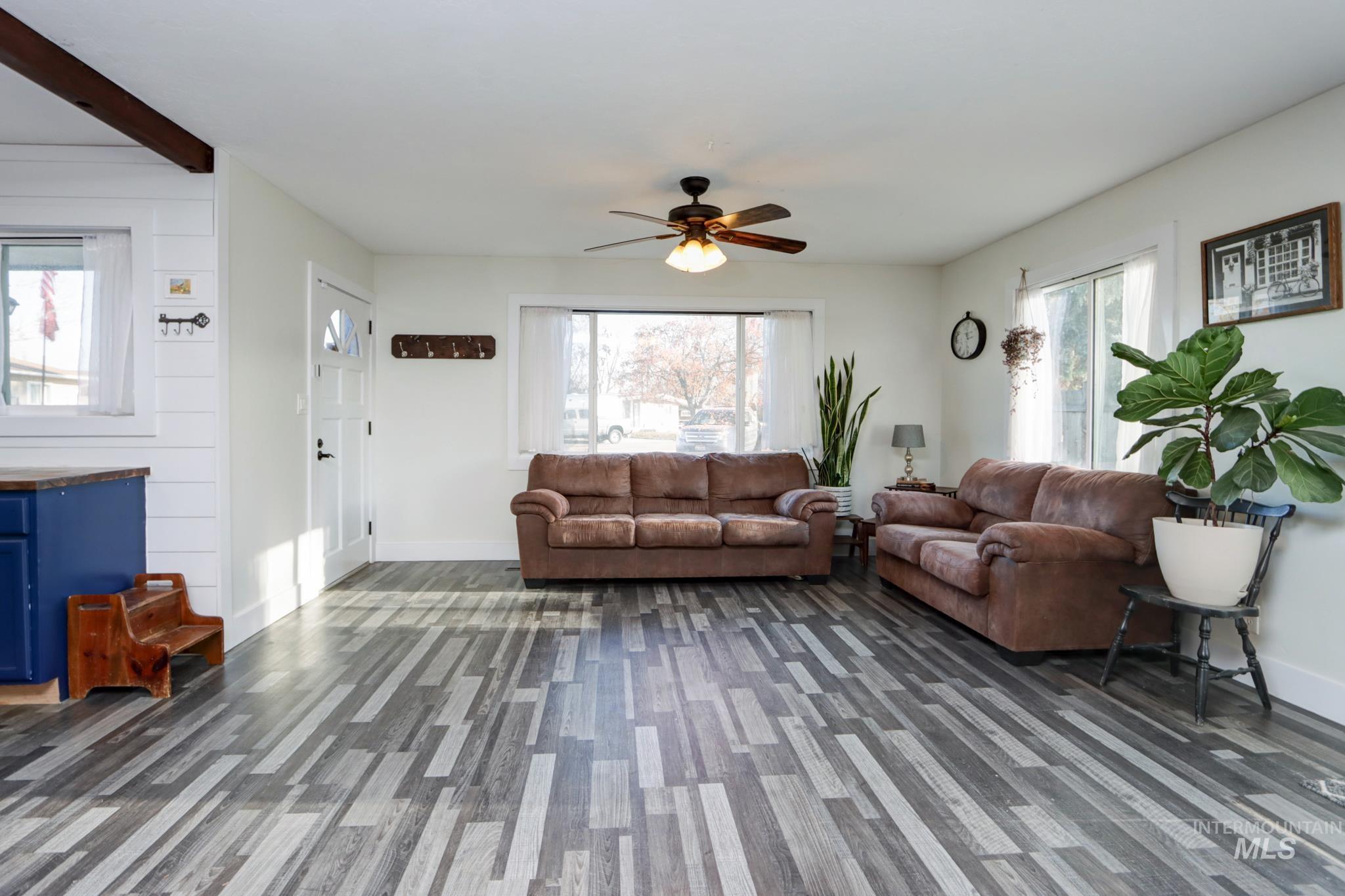 Living area with plenty of natural light, ceiling fan, and beam ceiling