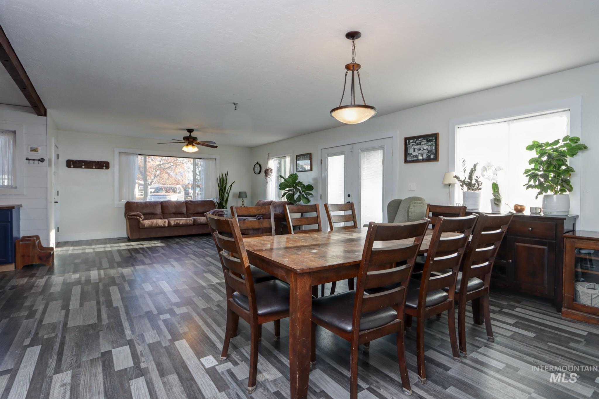 Dining room with ceiling fan, french doors, and dark wood-style flooring