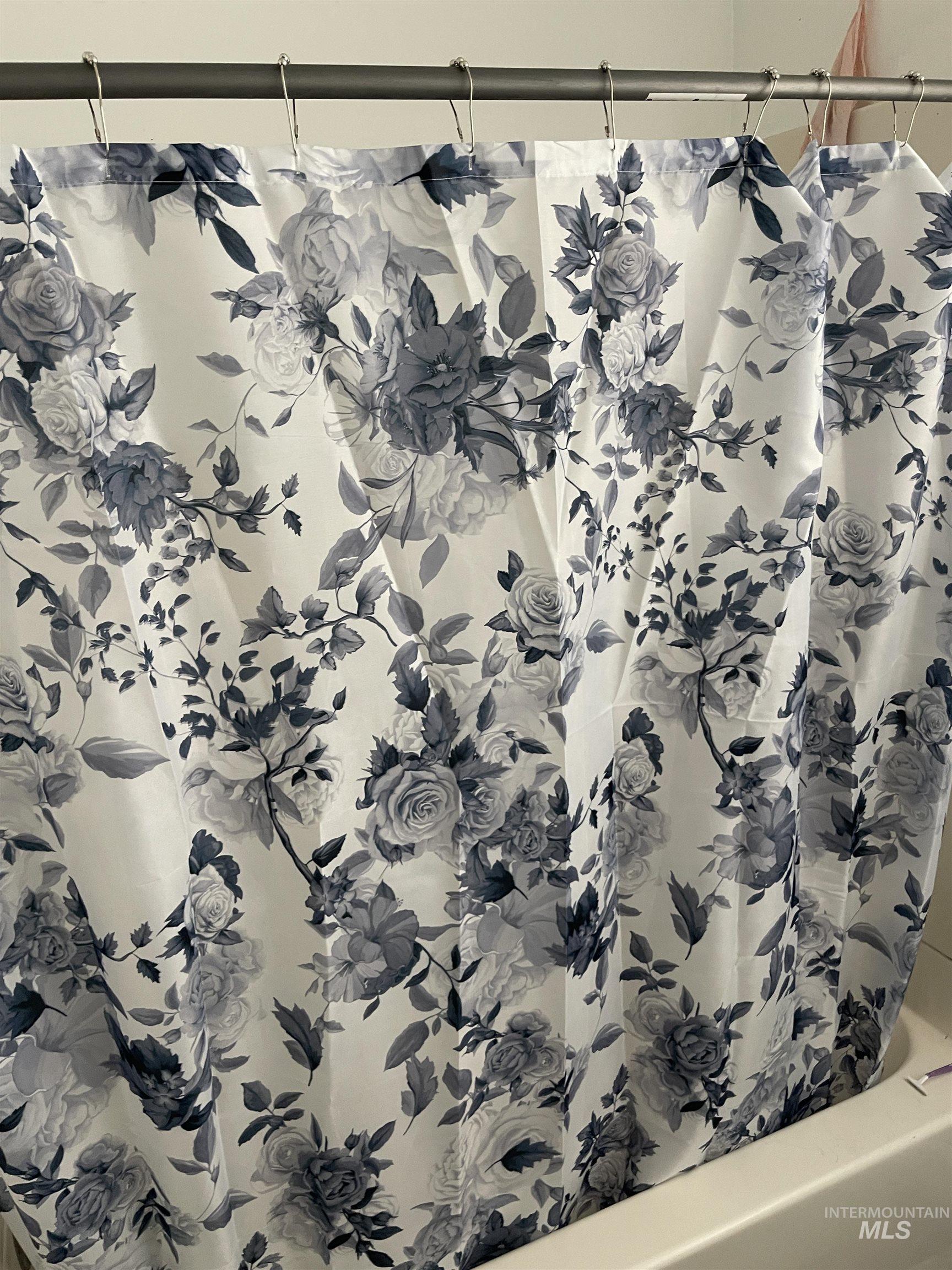 Bathroom view of shower / bath combo with shower curtain