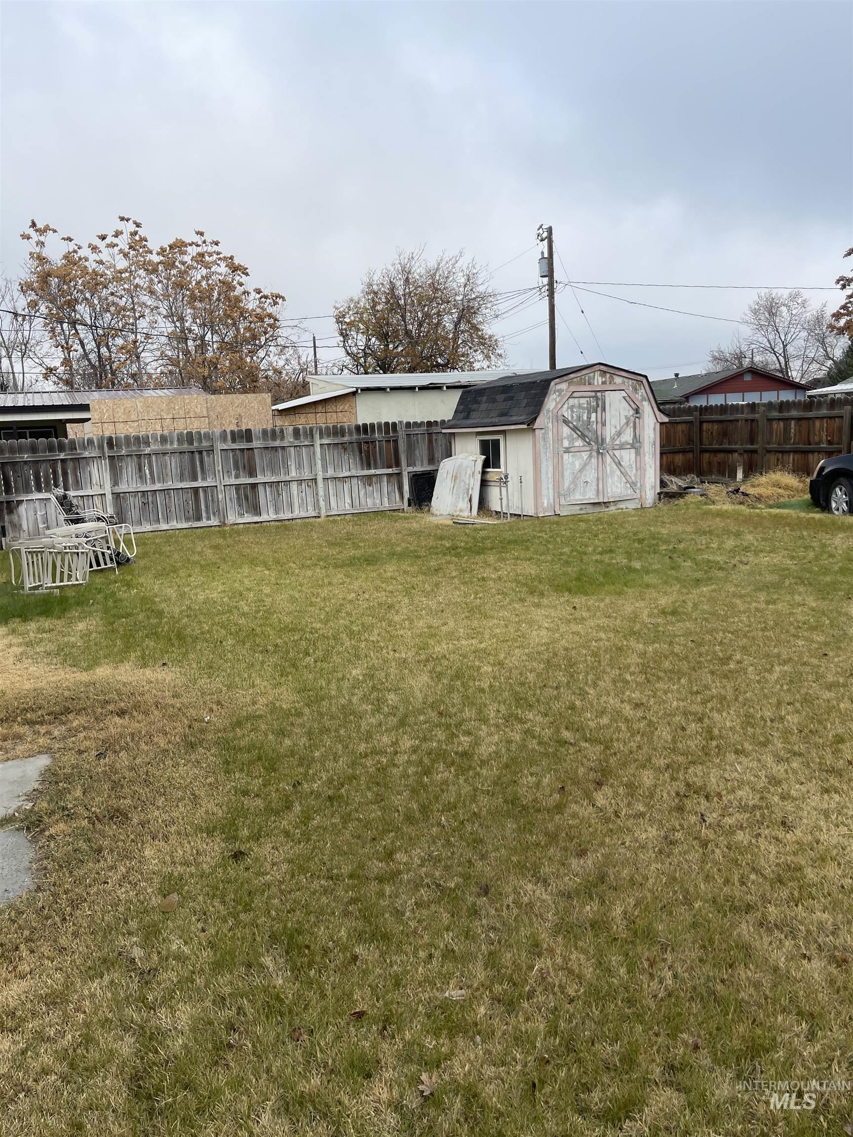 Rear view of property featuring a storage shed and a fenced backyard
