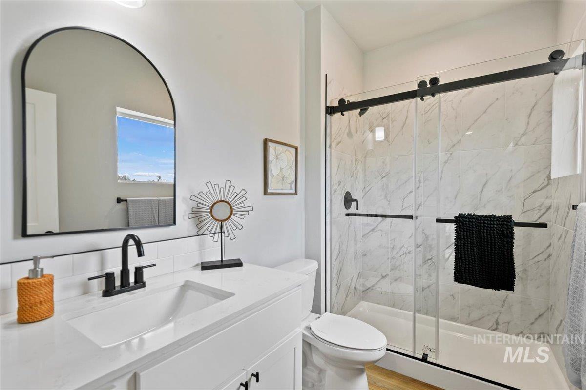 Bathroom featuring a marble finish shower and vanity