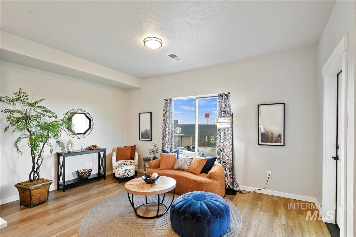 Living area featuring light wood-style flooring and a textured ceiling