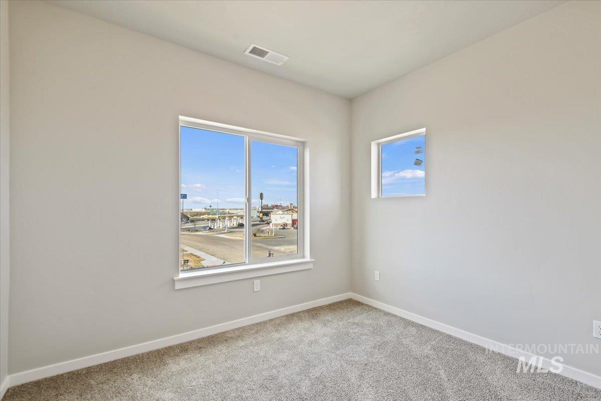 Carpeted spare room with baseboards