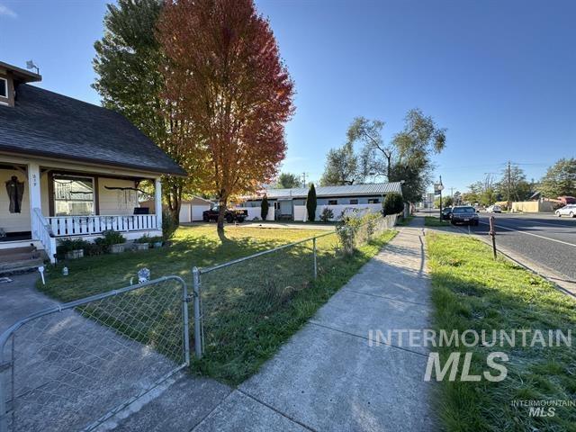 Fenced front yard featuring a gate and covered porch