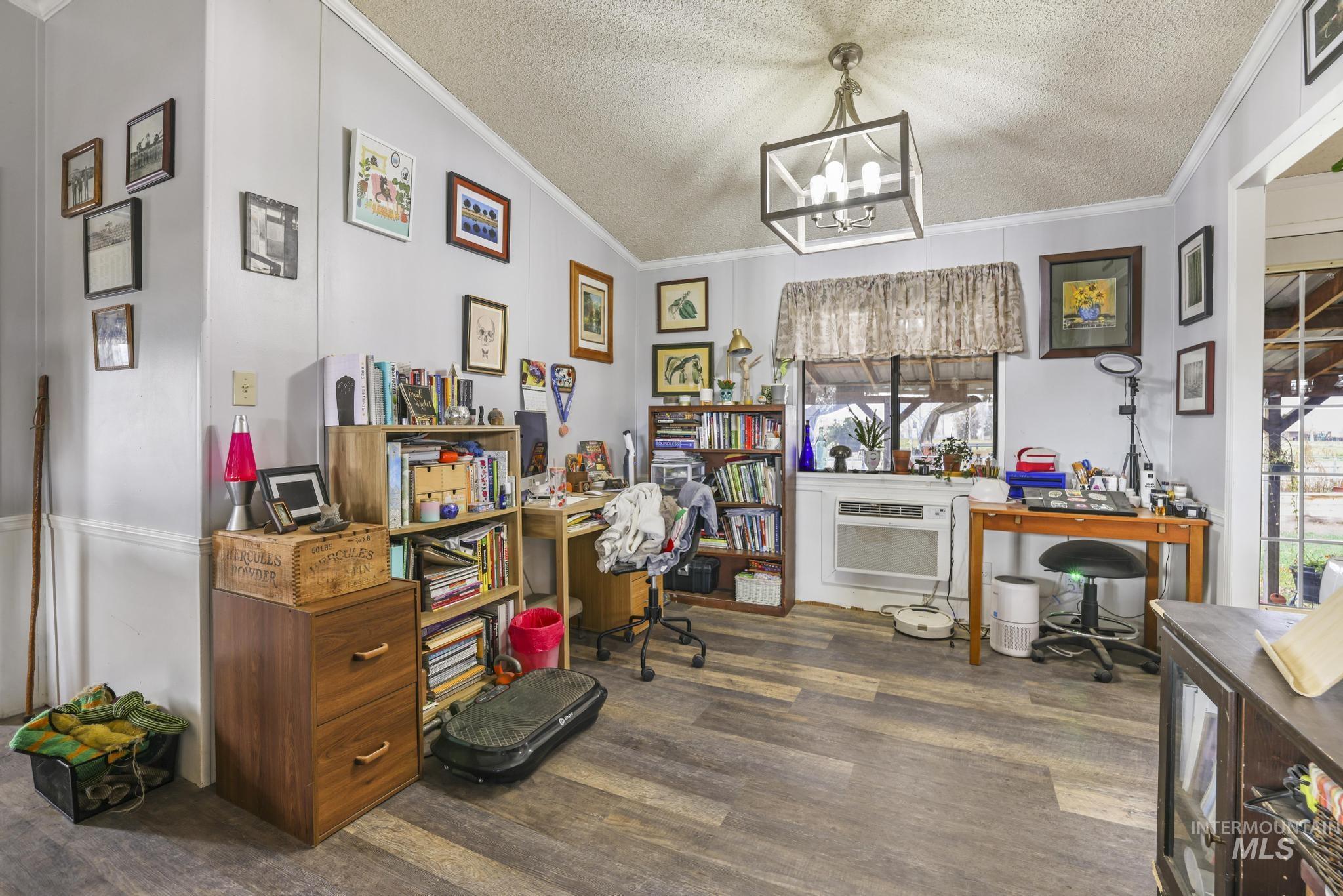 Home office featuring crown molding, dark wood finished floors, a textured ceiling, healthy amount of natural light, and a chandelier