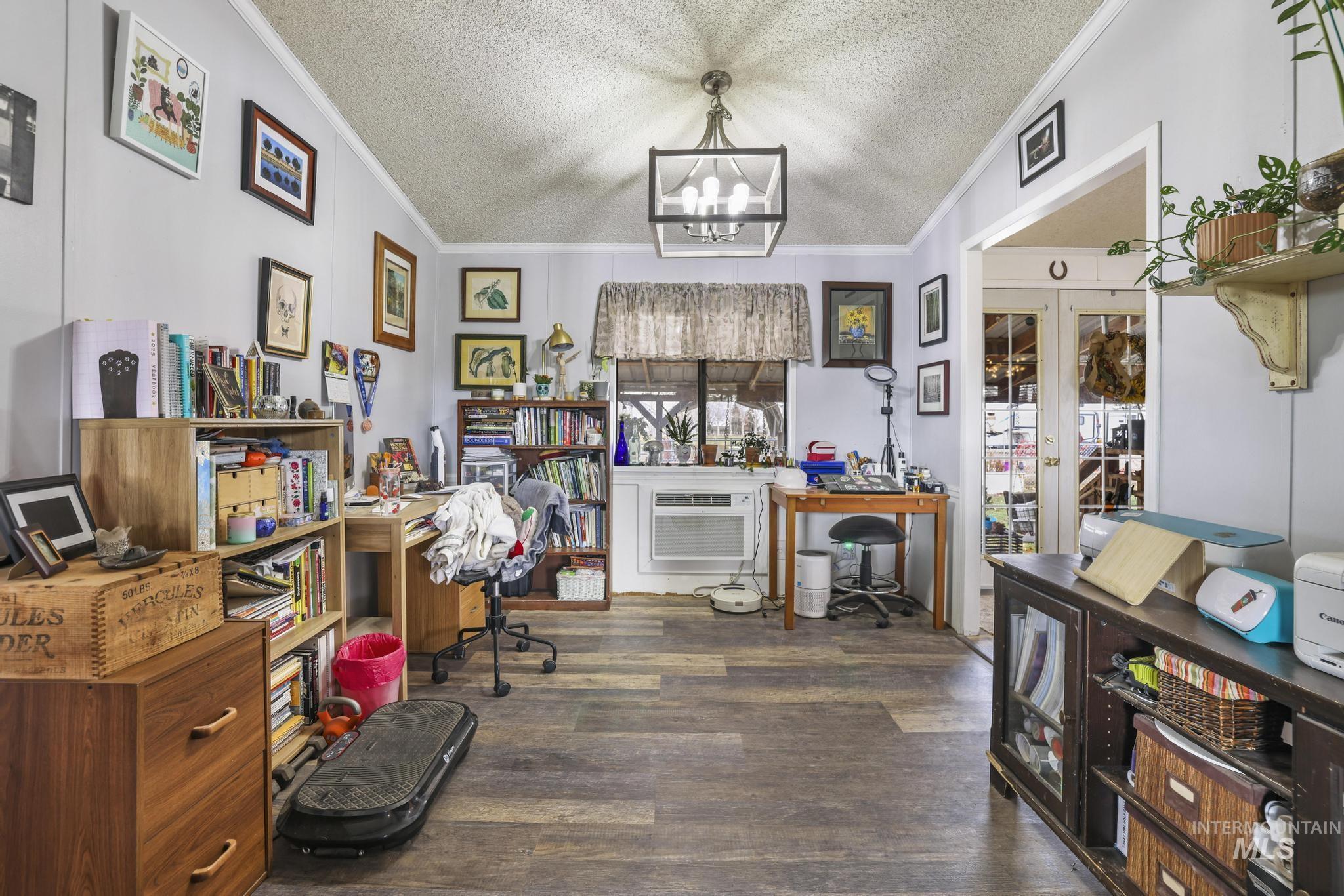 Home office featuring dark wood-style floors, crown molding, a textured ceiling, and a chandelier