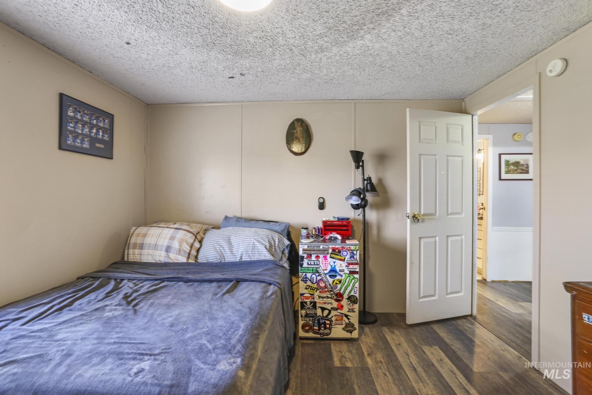 Bedroom featuring dark wood-style flooring and a textured ceiling