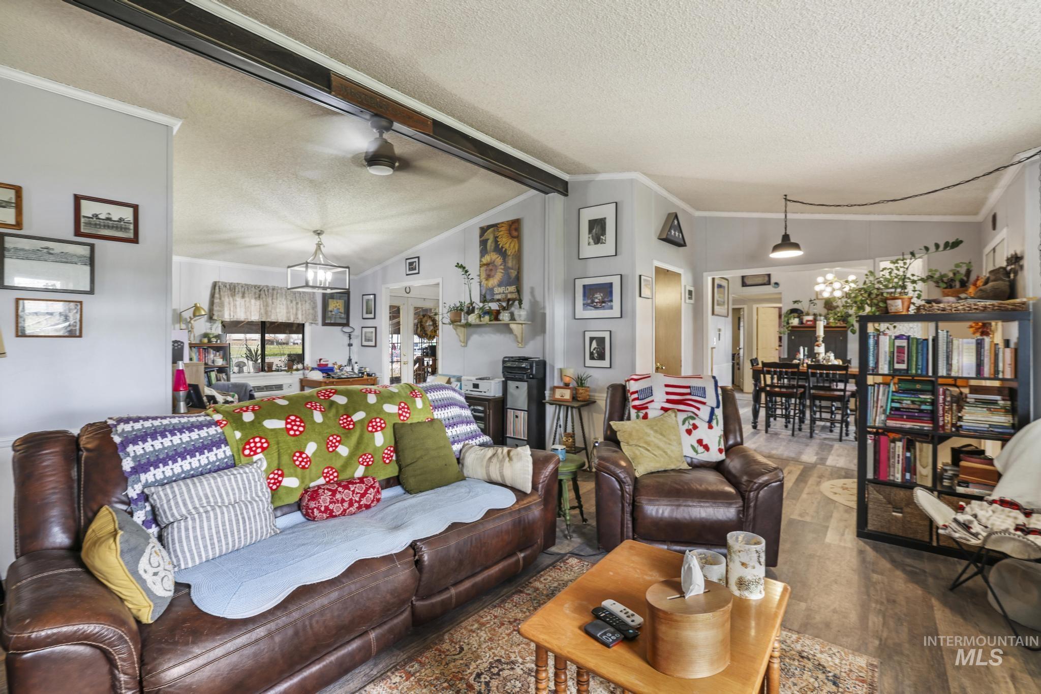 Living area with wood finished floors, a textured ceiling, ceiling fan, and a chandelier
