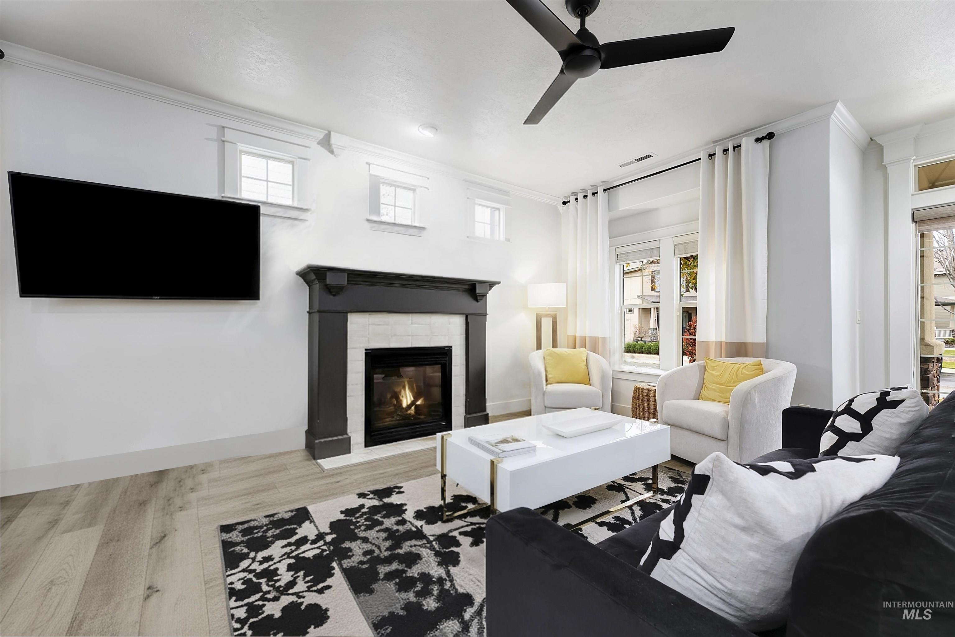 Living room features a cozy tiled fire place, large windows, and modern finishes.