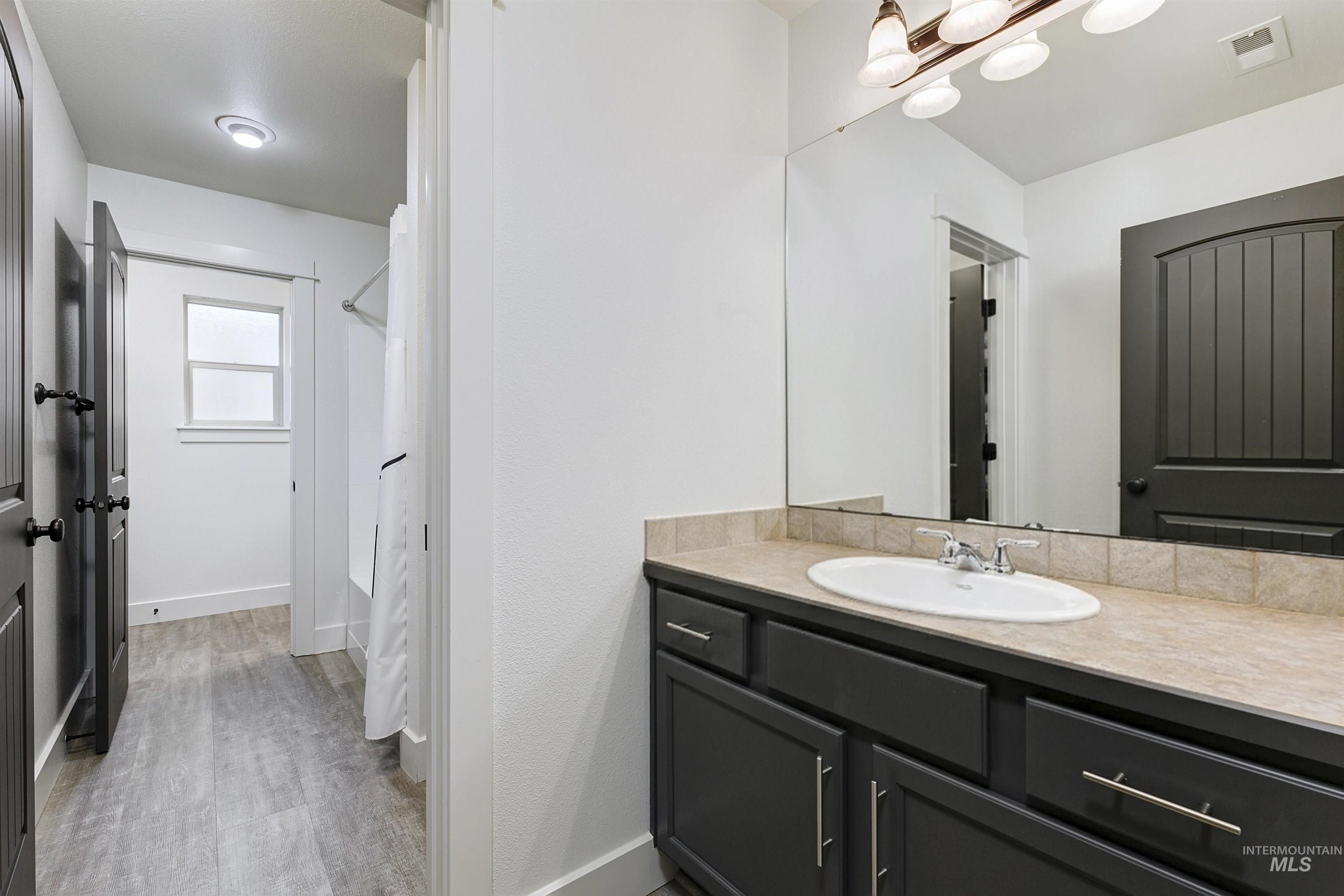 Guest Jack and Jill bathroom offers two vanities, a tub/shower combo and plenty of storage. The wide hallway and open layout creates a comfortable flow.