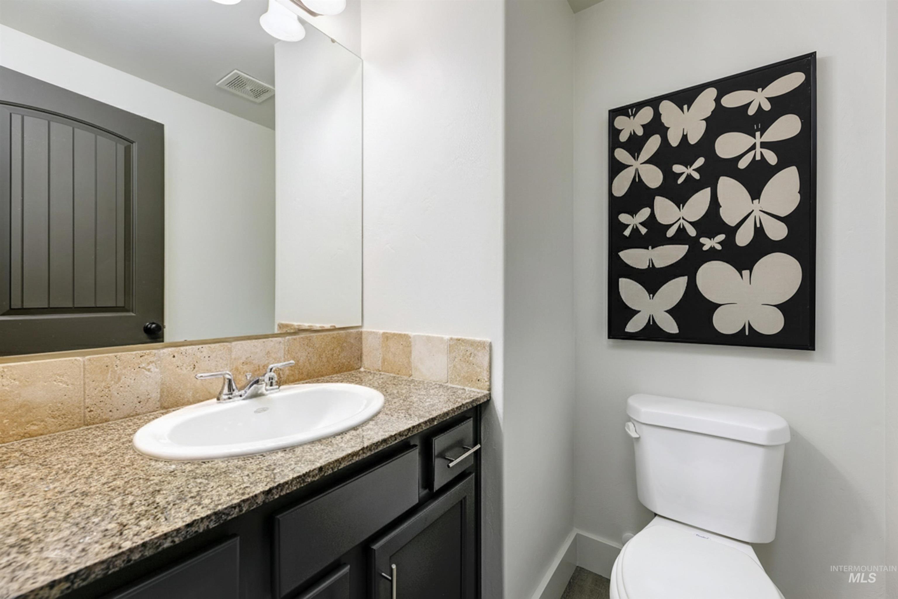 Half bathroom with a vanity and cabinetry.