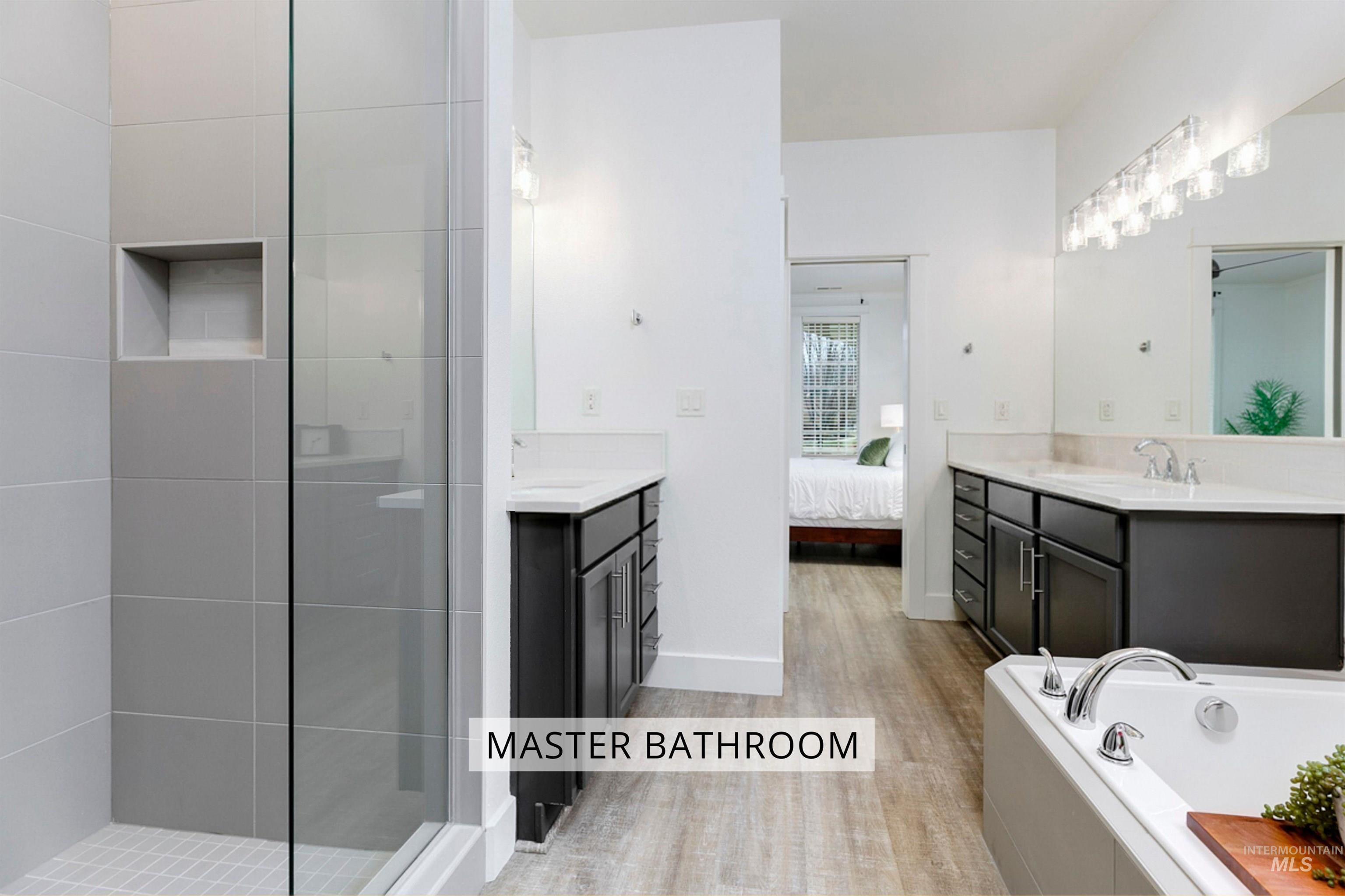This master bathroom features a large walk-in shower, large soaking tub, and plenty of counter space. The bright and clean design makes the space feel open, modern, and relaxing
