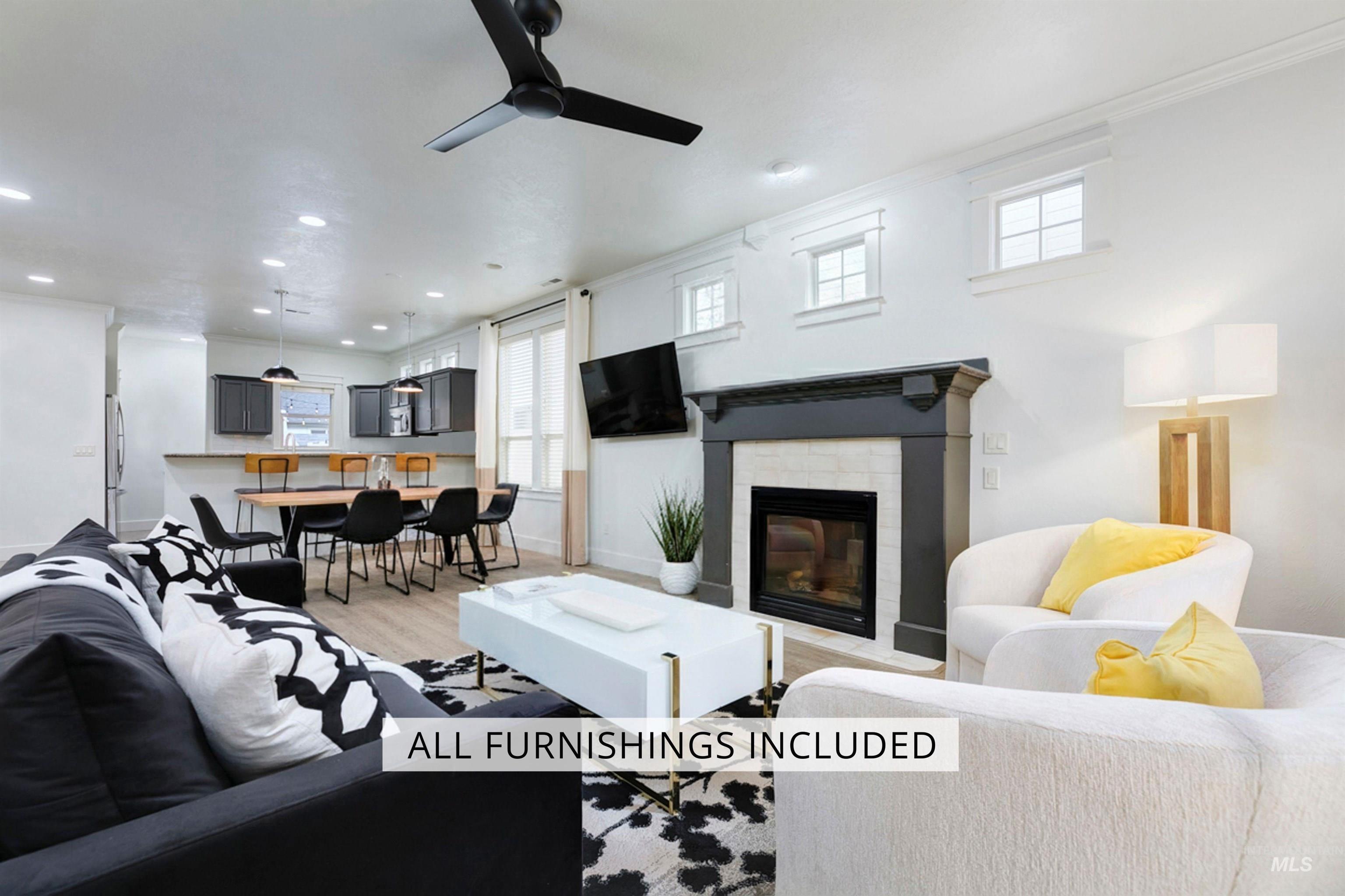 Living room with light wood finished floors, a tiled fireplace, a ceiling fan, crown molding, and recessed lighting