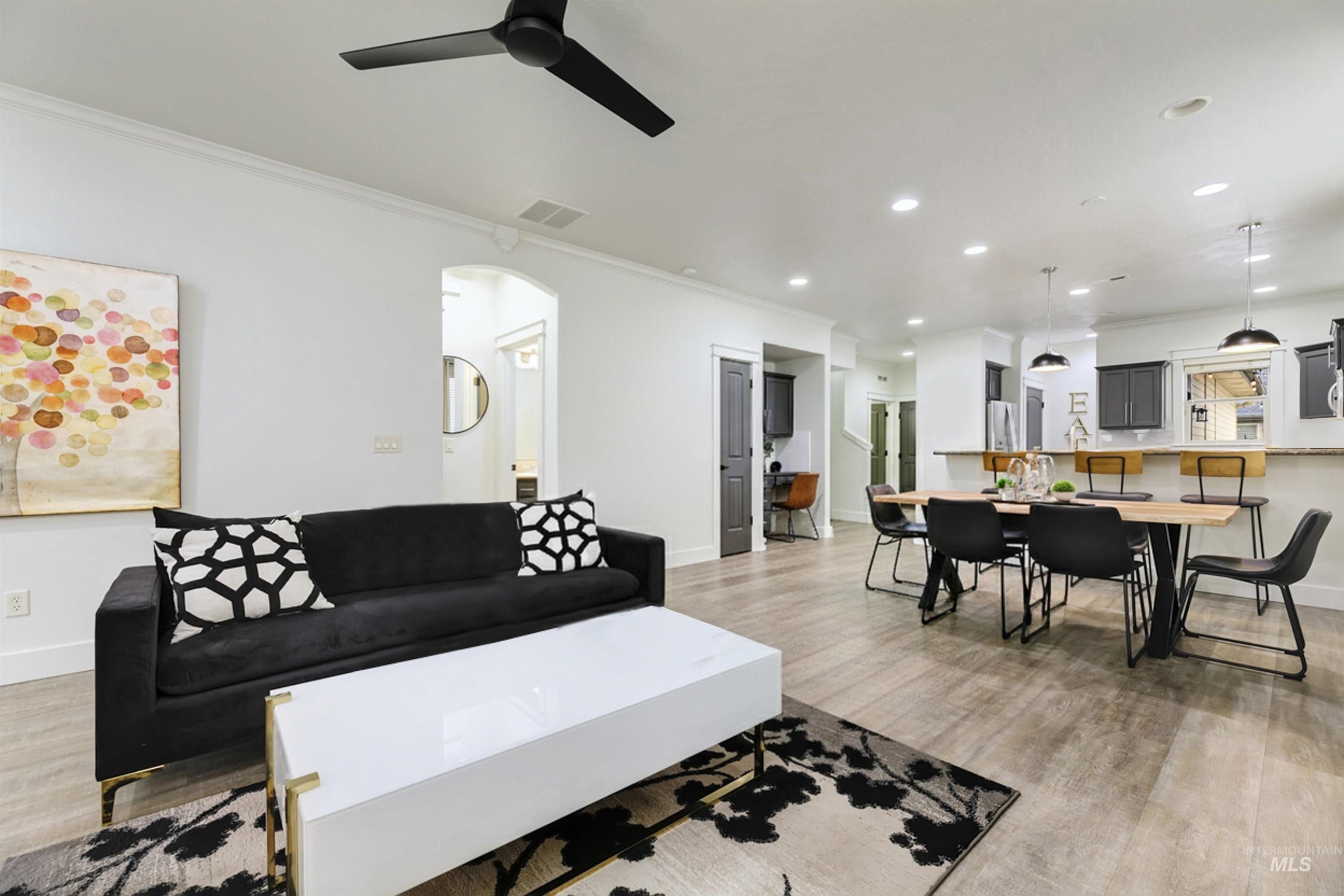 The open concept living room comes fully furnished, offering a seamless flow from the living room to the dining space and kitchen. Offers bright lighting and modern finishes.