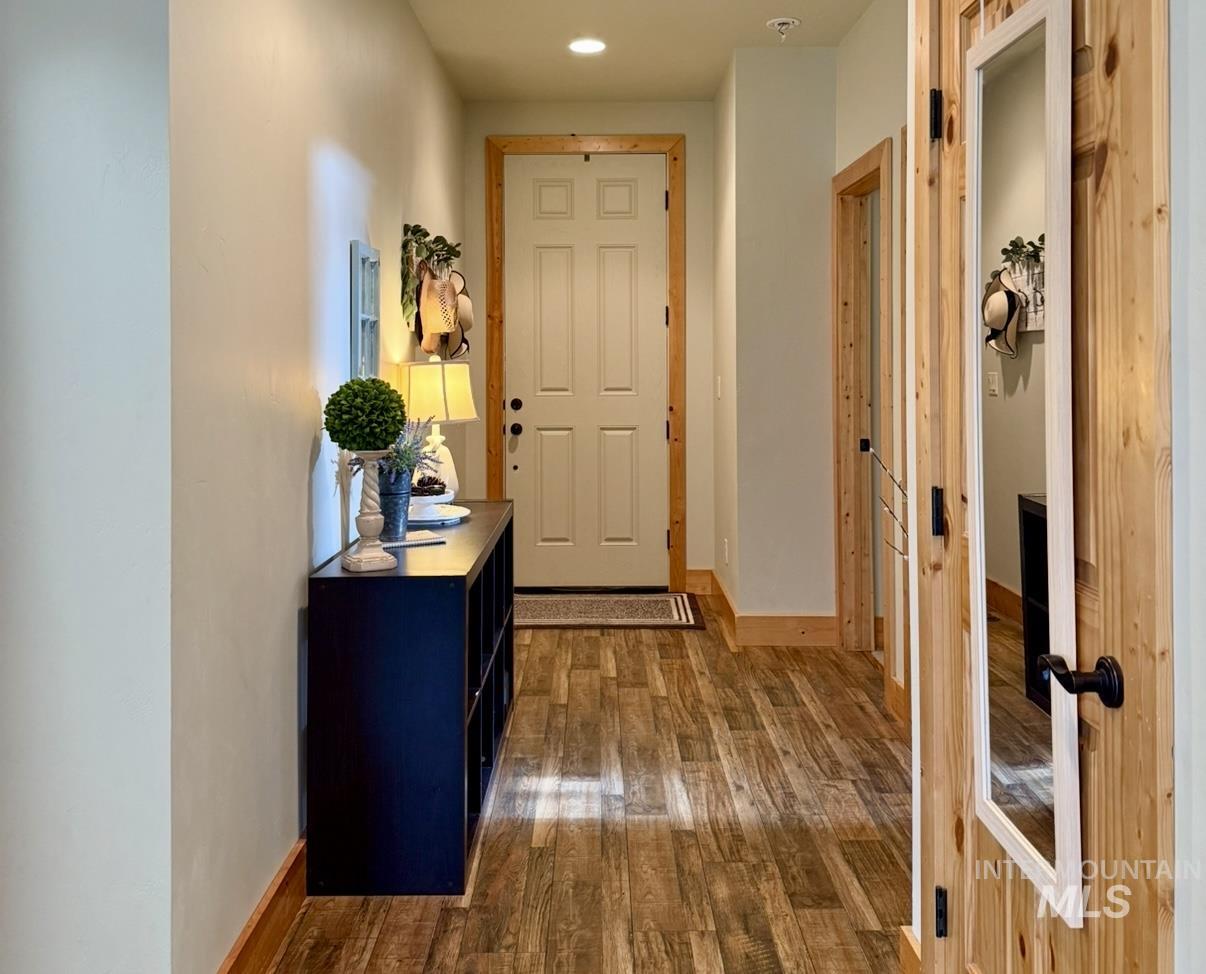 Hallway with dark wood-style flooring and recessed lighting