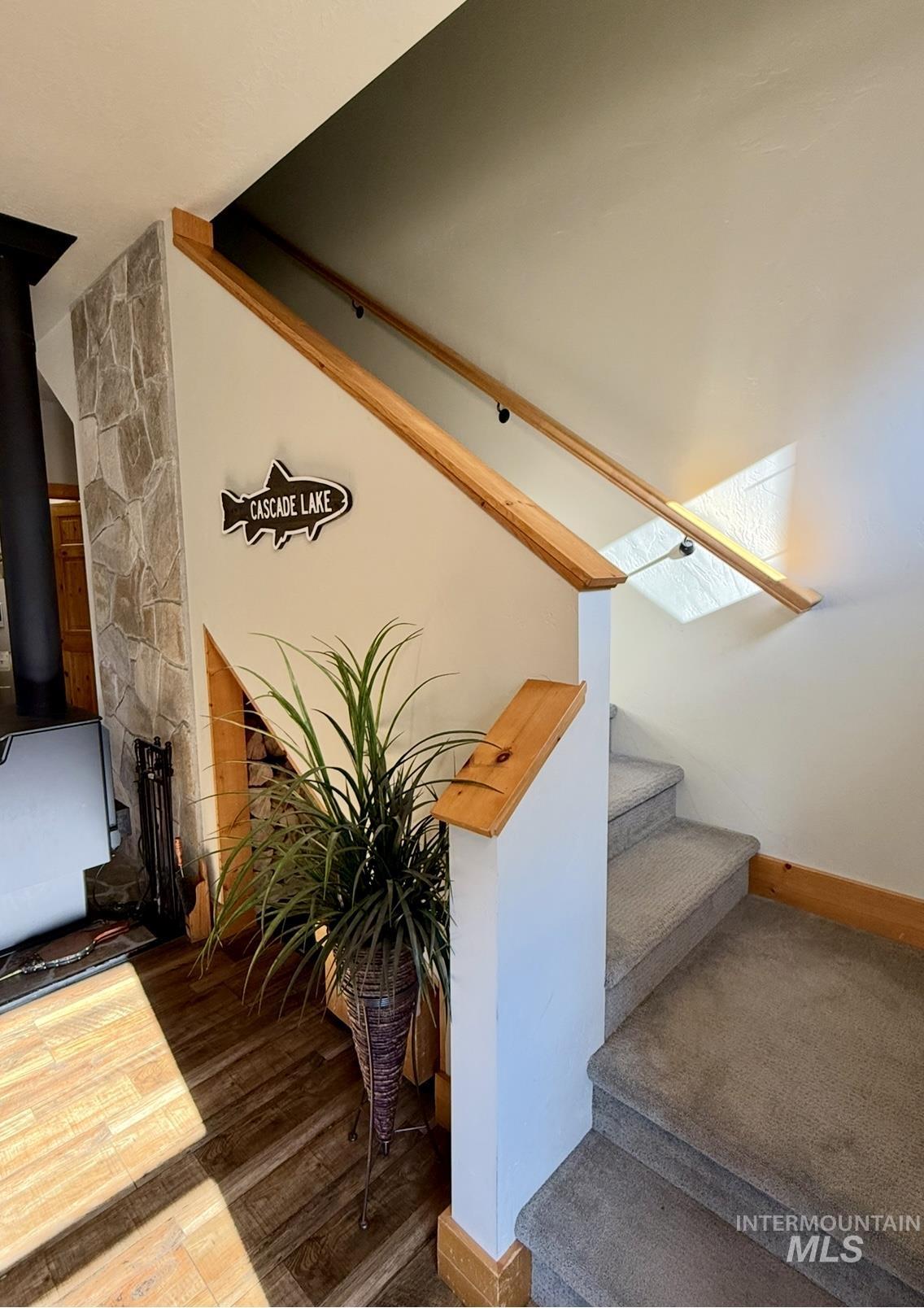 Staircase with a wood stove and wood finished floors